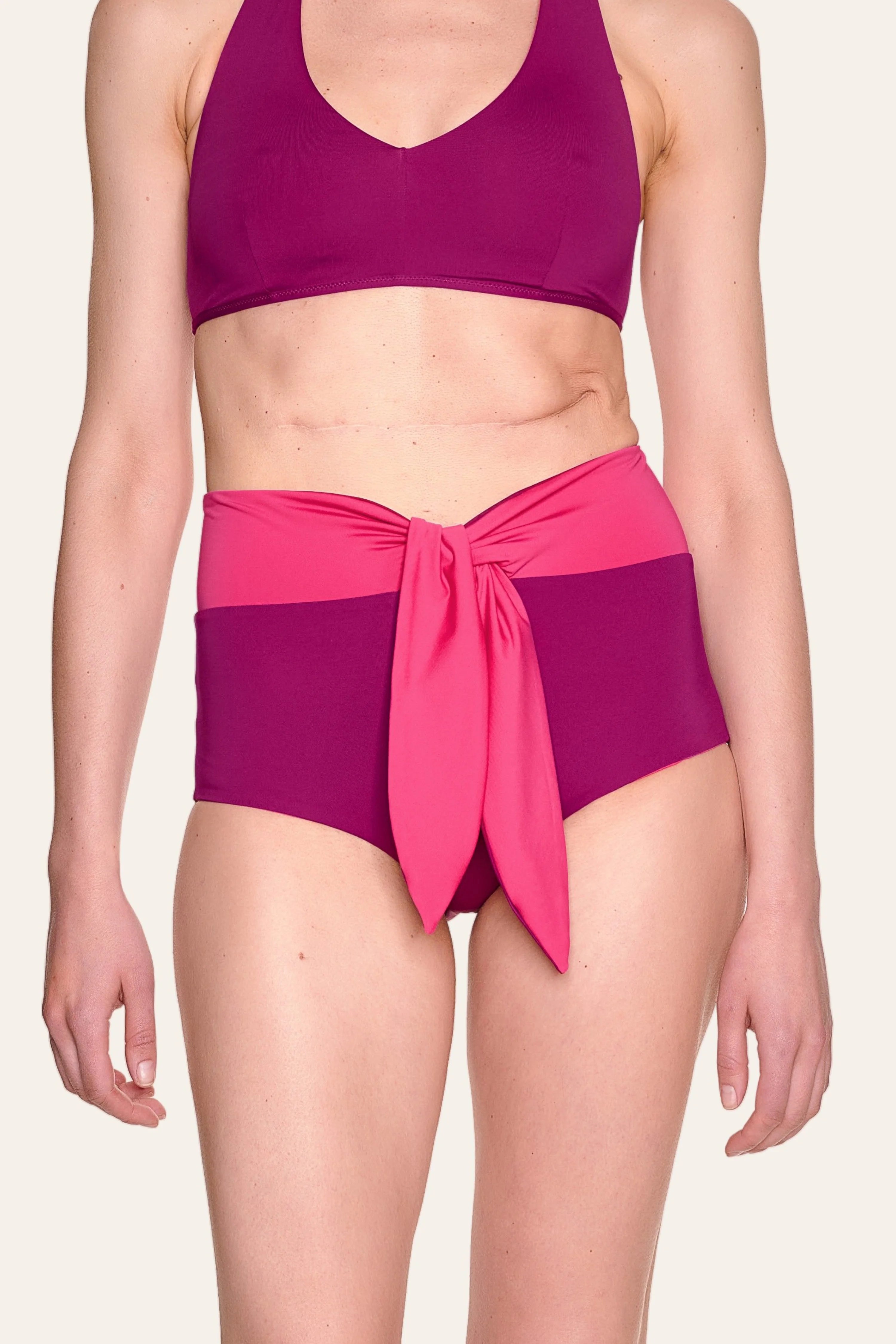 Frau trägt MYMARINI Bikinitop mit breiten Trägern und Bikinihose mit hohem Bund und Schleife in Pink- und Violetttönen.#color_pink-hortensia