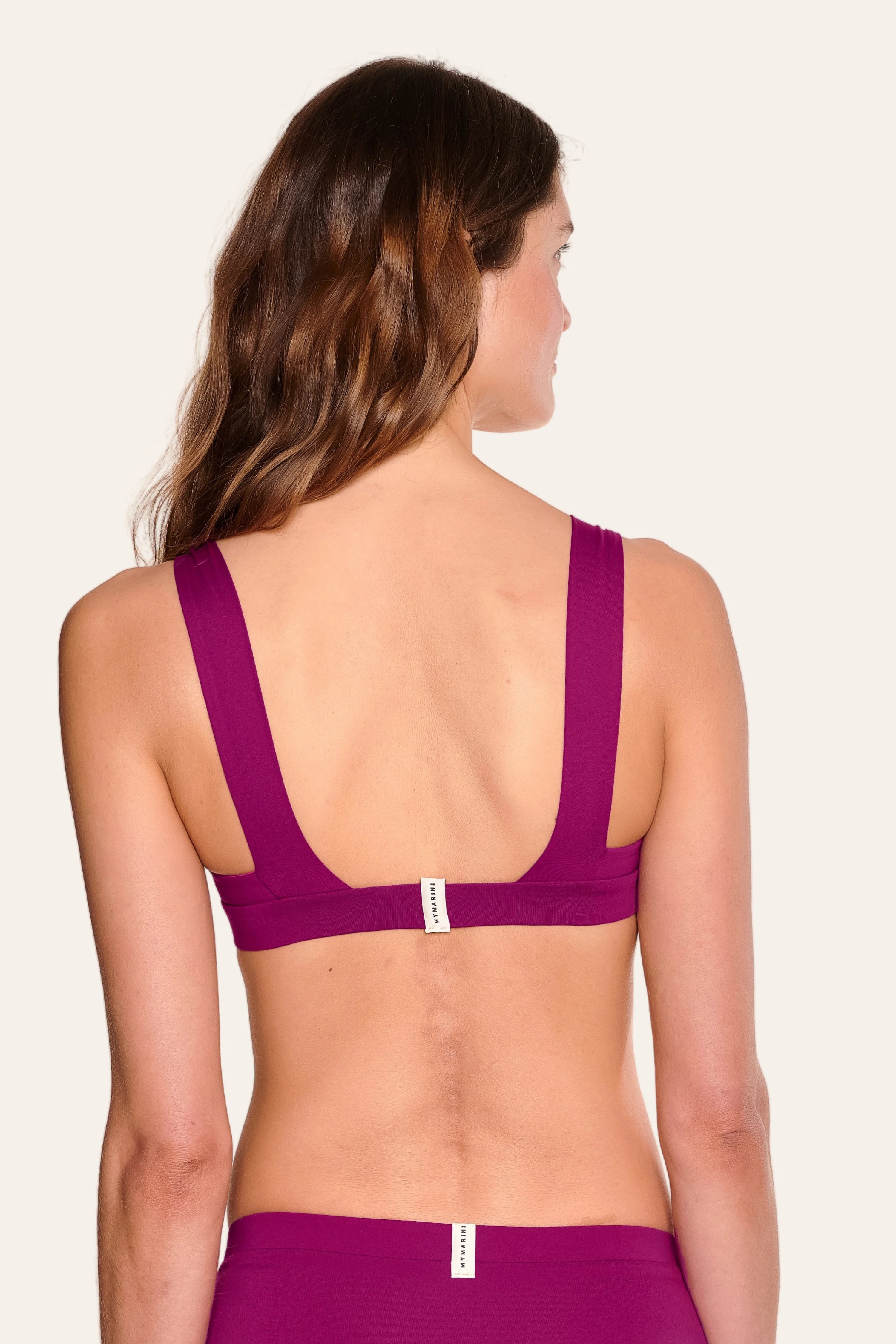 Frau trägt ein MYMARINI Bikinitop mit breiten Trägern und tiefem Rückenausschnitt in Lila.#color_pink-hortensia