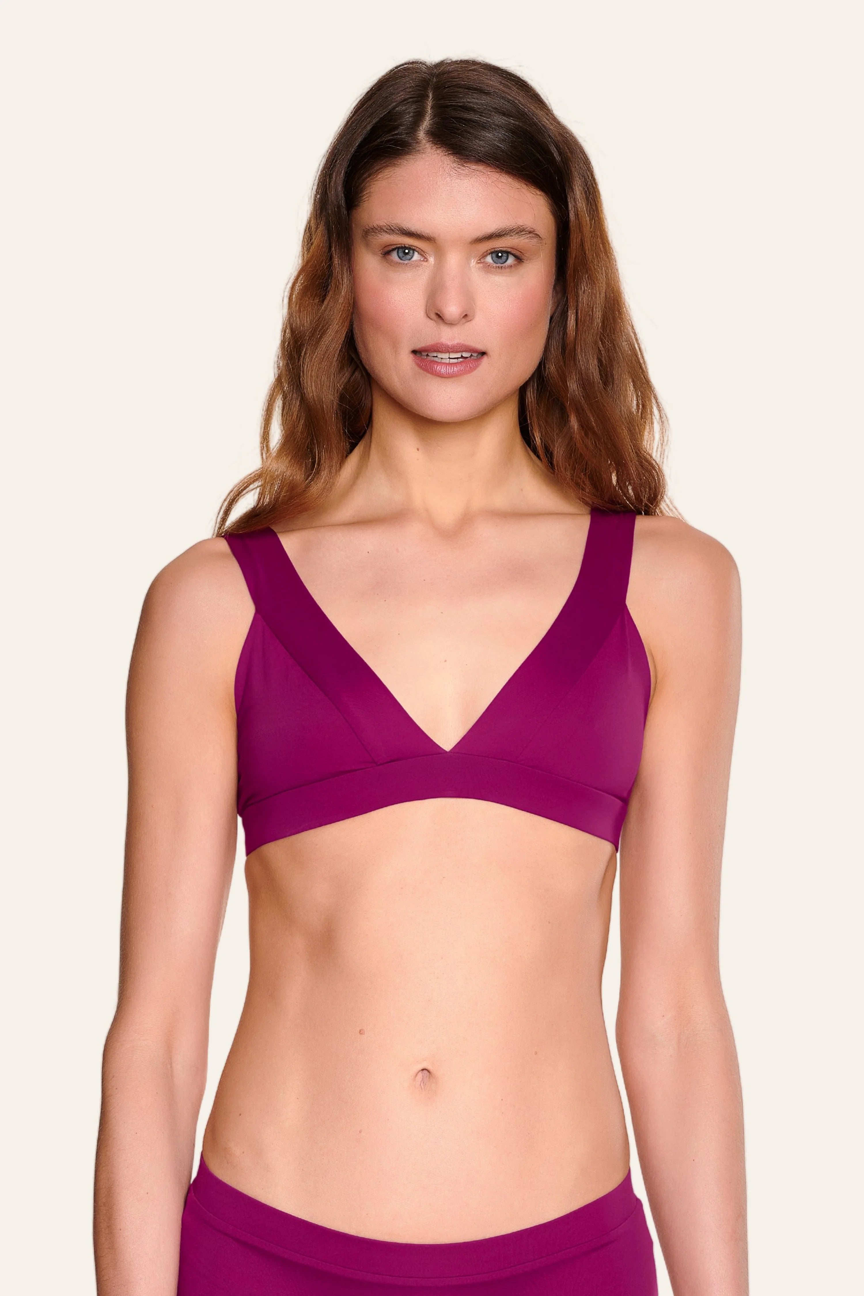 Frau trägt MYMARINI Bikinitop mit V-Ausschnitt und breiten Trägern in kräftigem Pink.#color_pink-hortensia