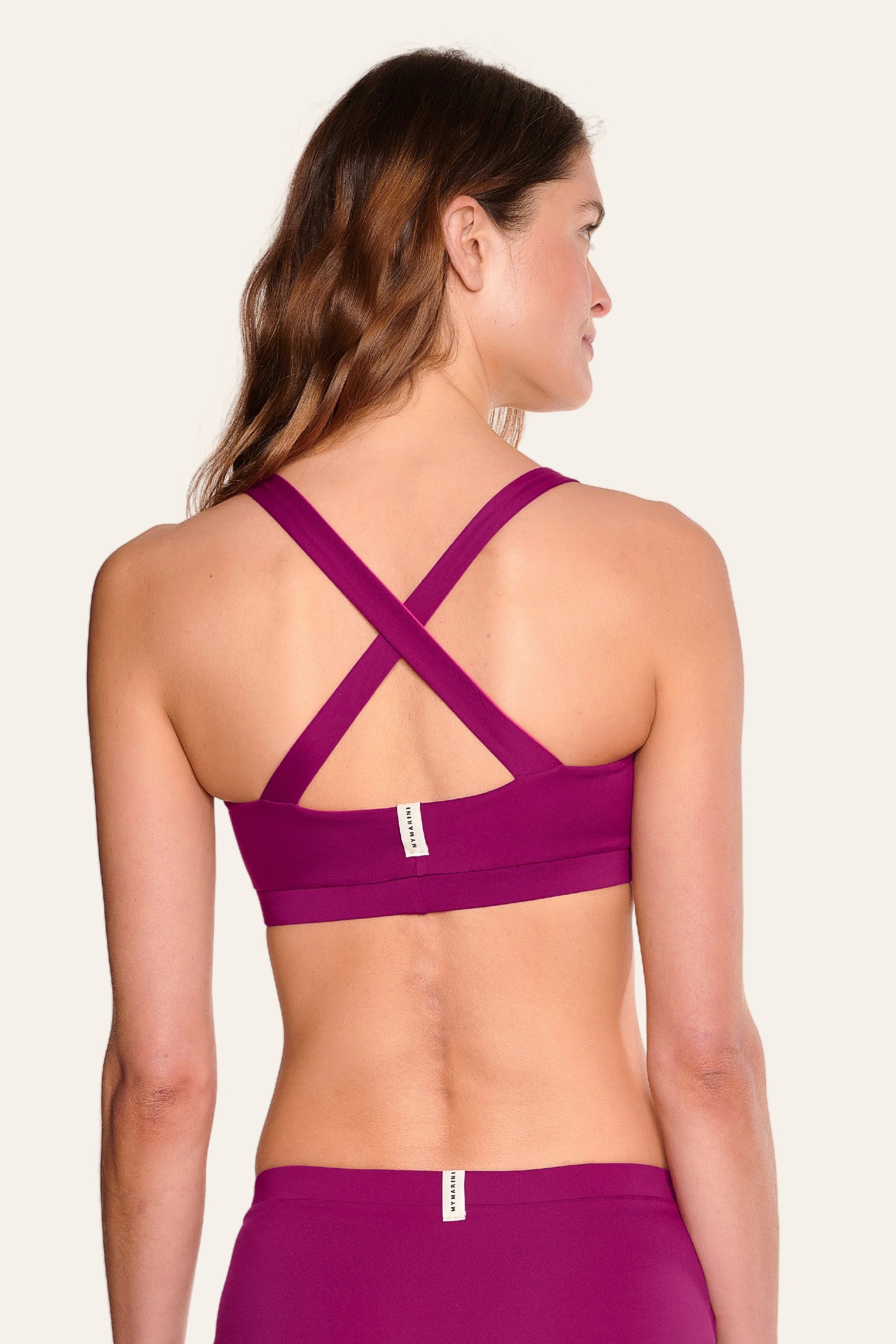 Frau in MYMARINI Bikinitop mit breiten, überkreuzten Trägern, Rückenansicht.#color_pink-hortensia