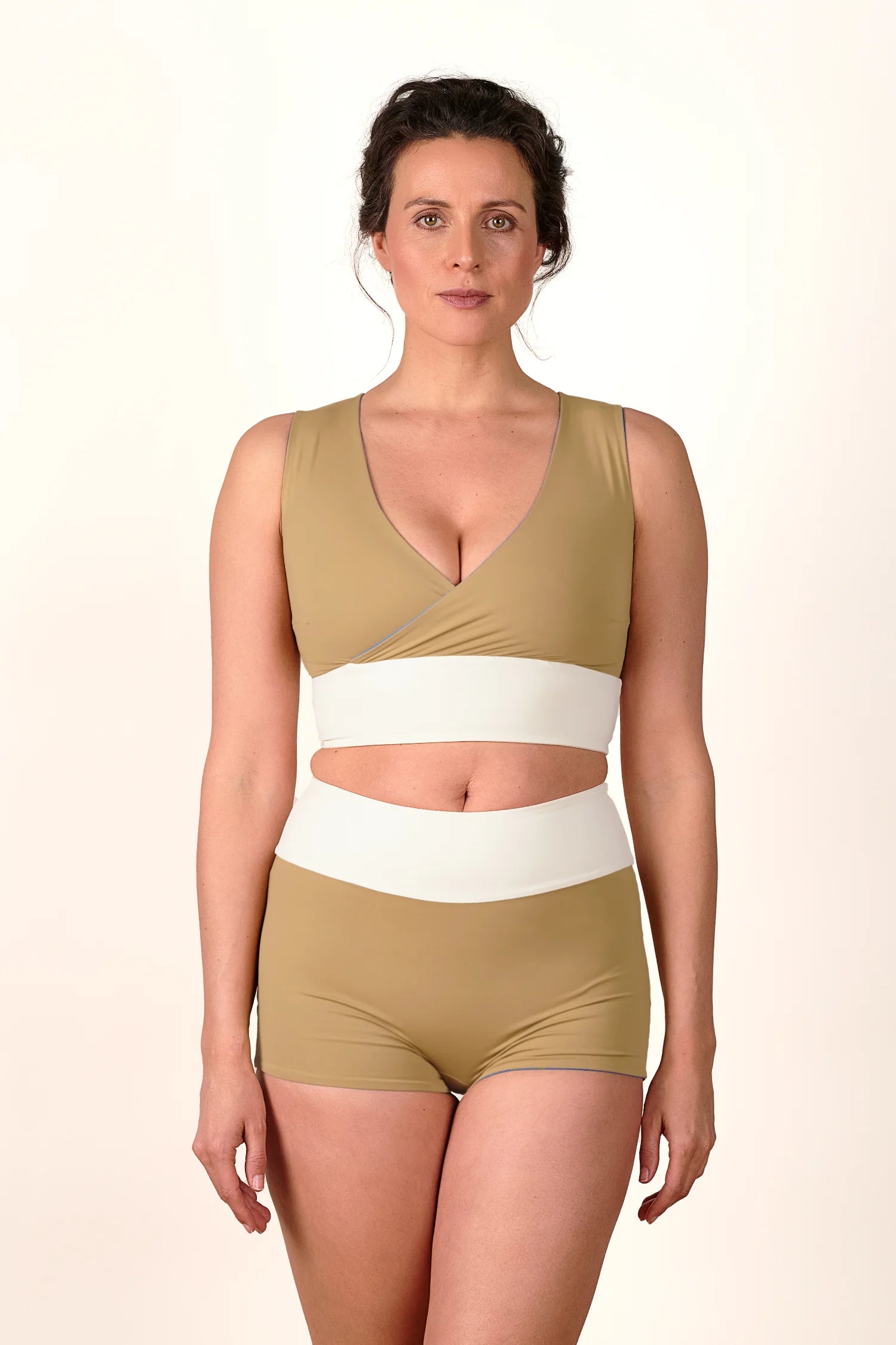 Frau trägt MYMARINI Bikinitop mit V-Ausschnitt und Bikinihose in High Waist.#color_coast-desert