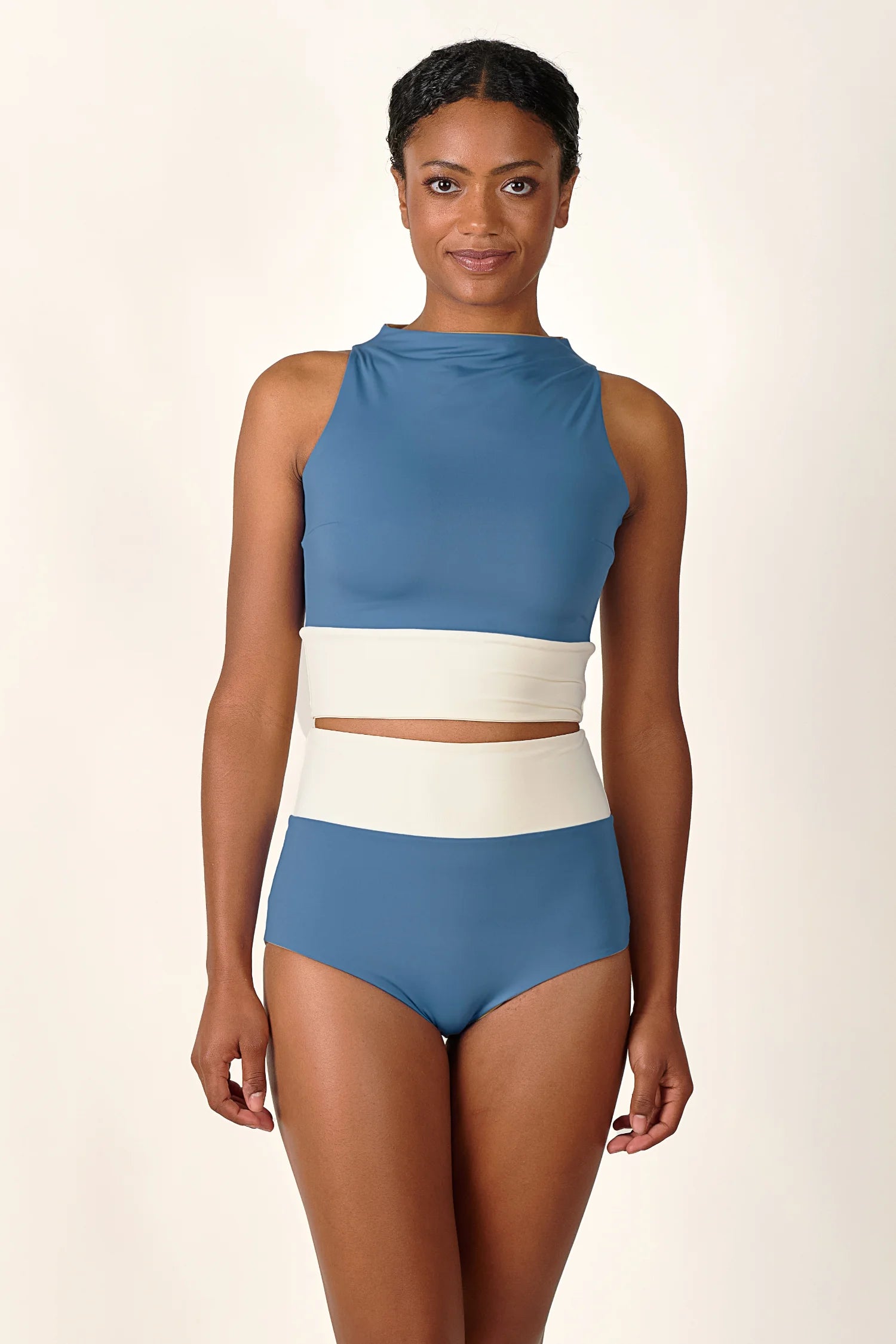 Person trägt MYMARINI Badeanzug mit hoch geschlossenem Schnitt und hohem Beinausschnitt in Blau und Weiß.#color_coast-desert