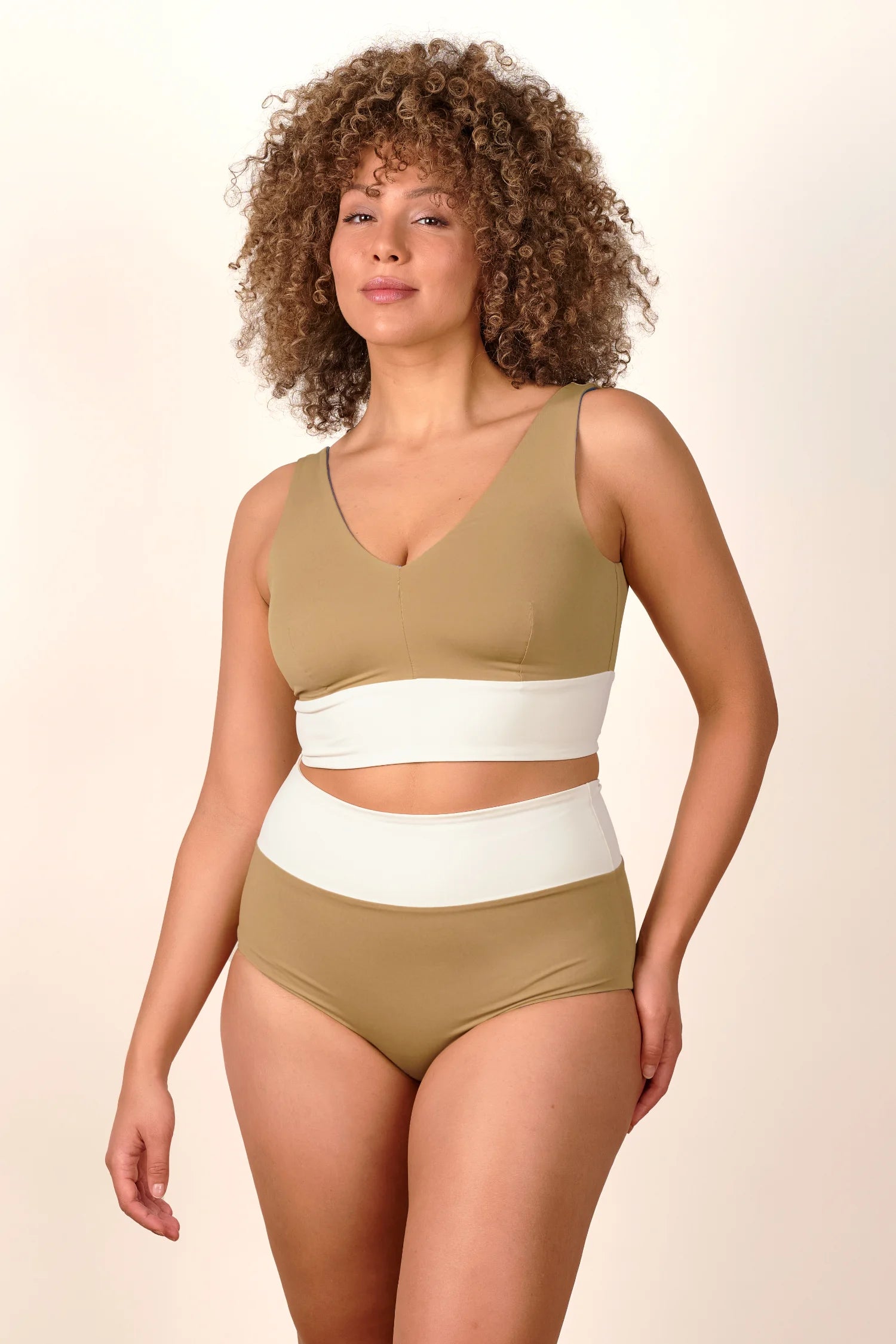 Frau trägt MYMARINI Bikini mit V-Ausschnitt und High Waist in Beige und Weiß.#color_coast-desert