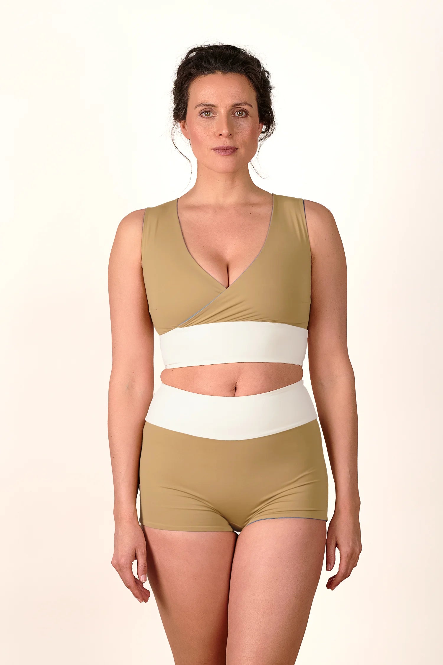 Frau trägt MYMARINI Bikinitop mit V-Ausschnitt und Bikinihose mit High Waist in Beige und Weiß.#color_coast-desert