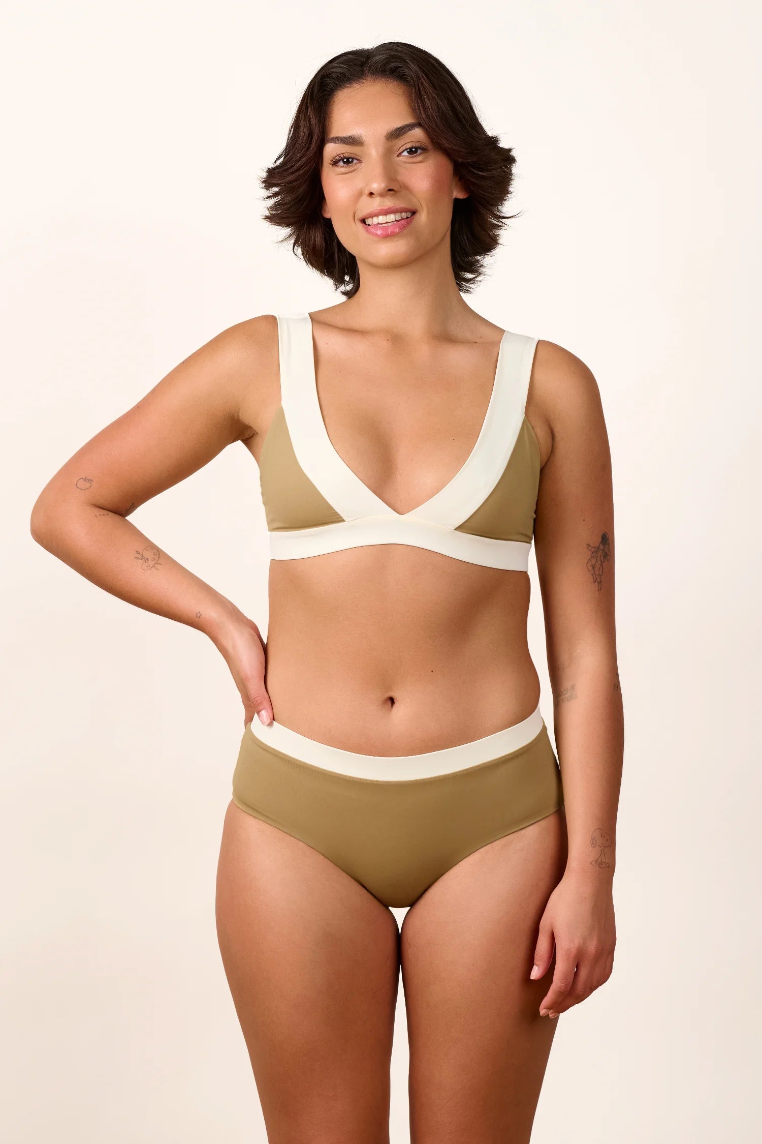 Frau trägt MYMARINI Bikini mit V-Ausschnitt und breiten Trägern in Beige und Weiß.#color_coast-desert