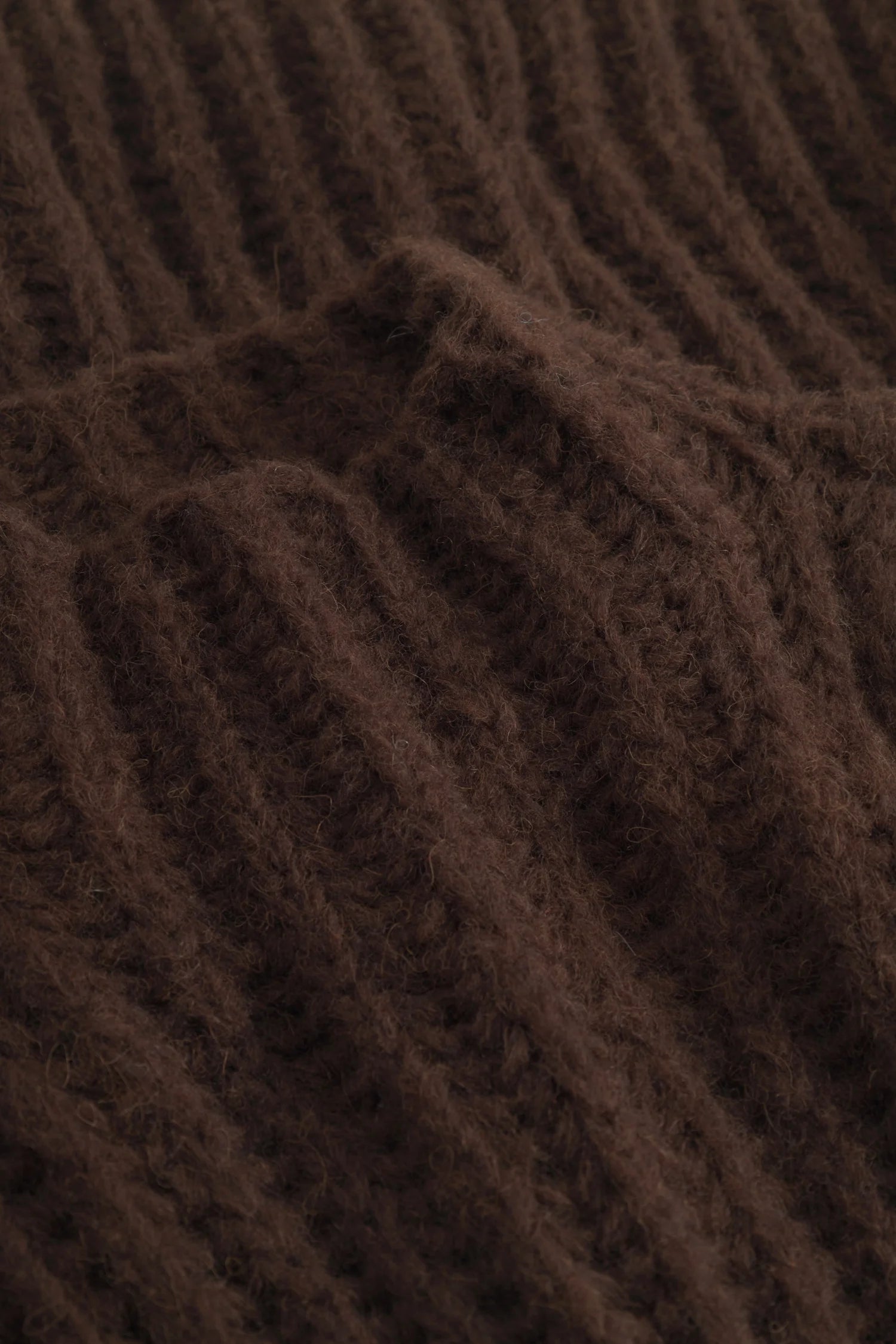 Brauner, gerippter Strickstoff in Nahaufnahme, zeigt die Textur und Struktur des Materials.#color_camel
