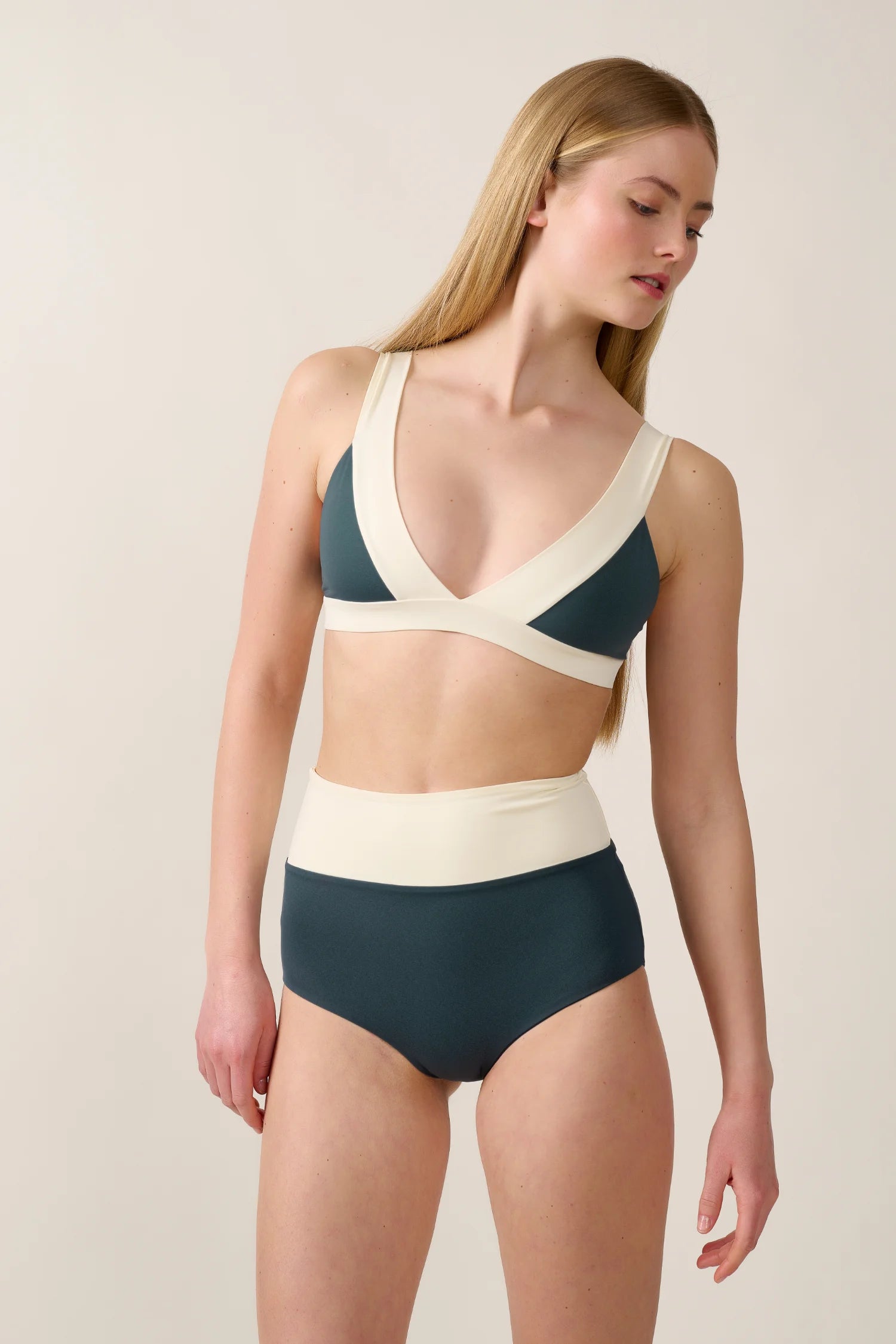 Frau trägt MYMARINI Bikini mit V-Ausschnitt und High Waist in Creme und Dunkelgrün.#color_black-grey-white
