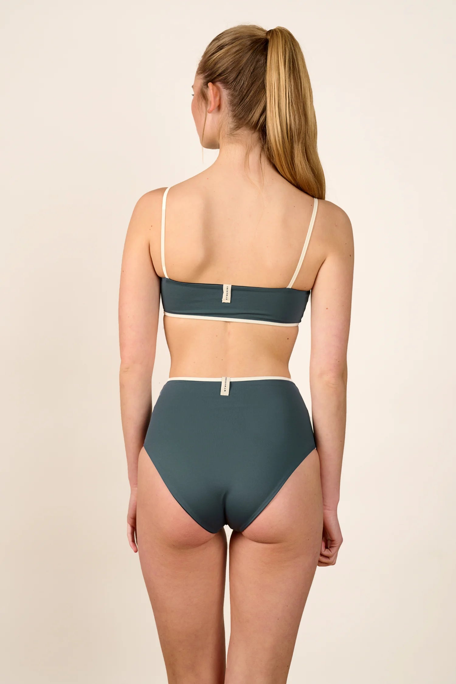 Frau in MYMARINI Bikini mit Spaghettiträgern und hohem Beinausschnitt, Rückansicht.#color_black-grey-white