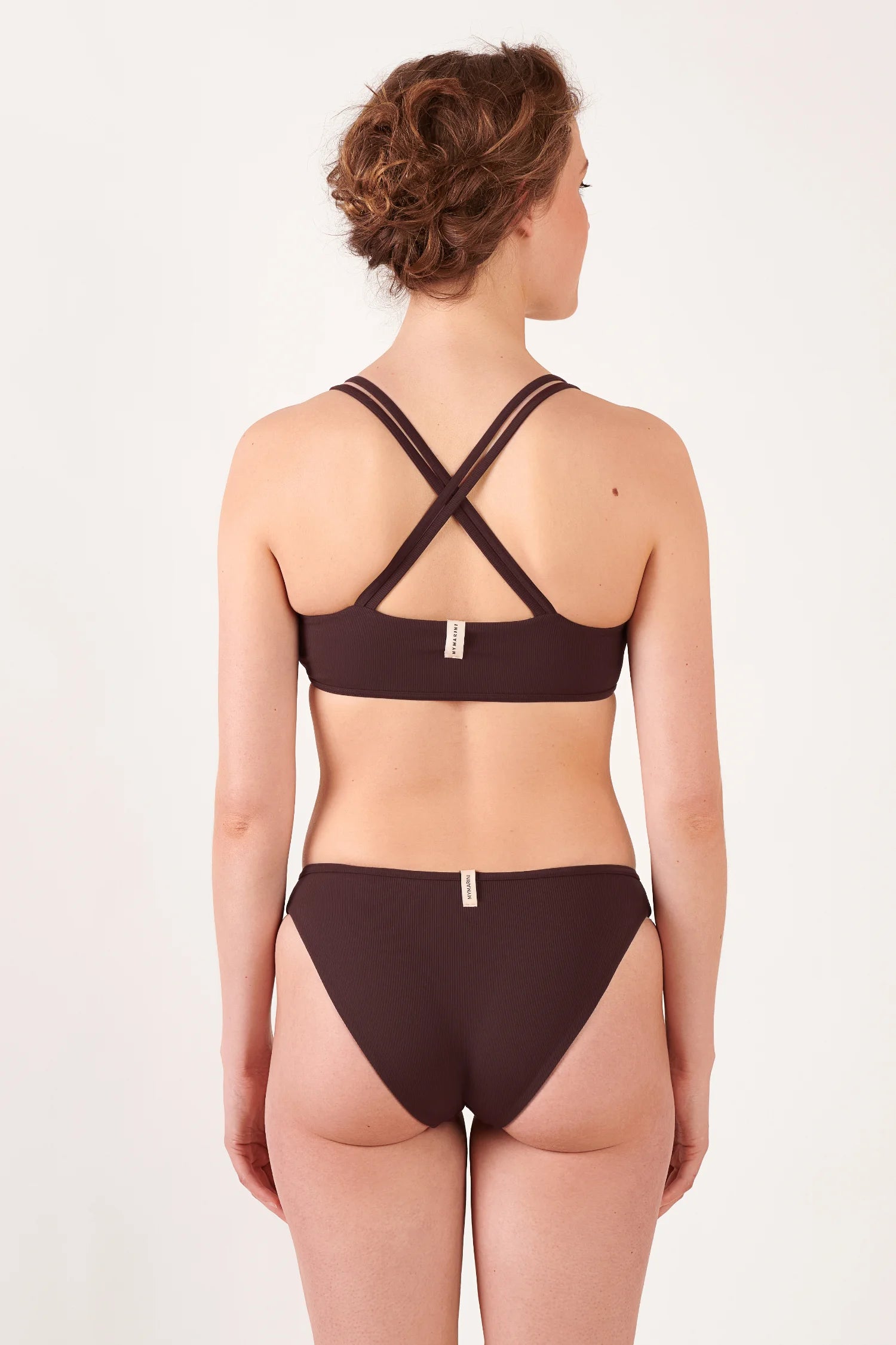 Bikinitop und Bikinihose von MYMARINI in Braun, mit gekreuzten Trägern und hohem Beinausschnitt, von hinten sichtbar.#color_chocolate
