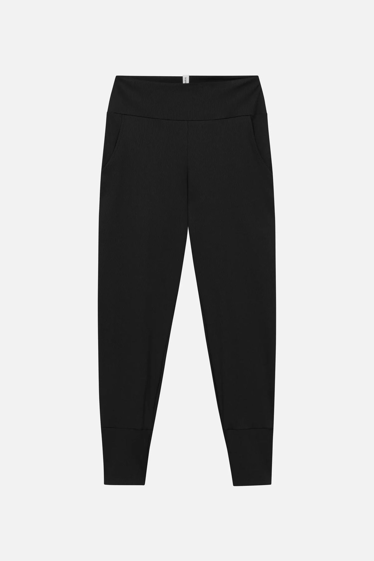 Schwarze MYMARINI LOOSE LEGGINGS mit breitem Bund, Seitentaschen und Bündchen, Vorderseite auf hellem Grund#color_black-ribbed