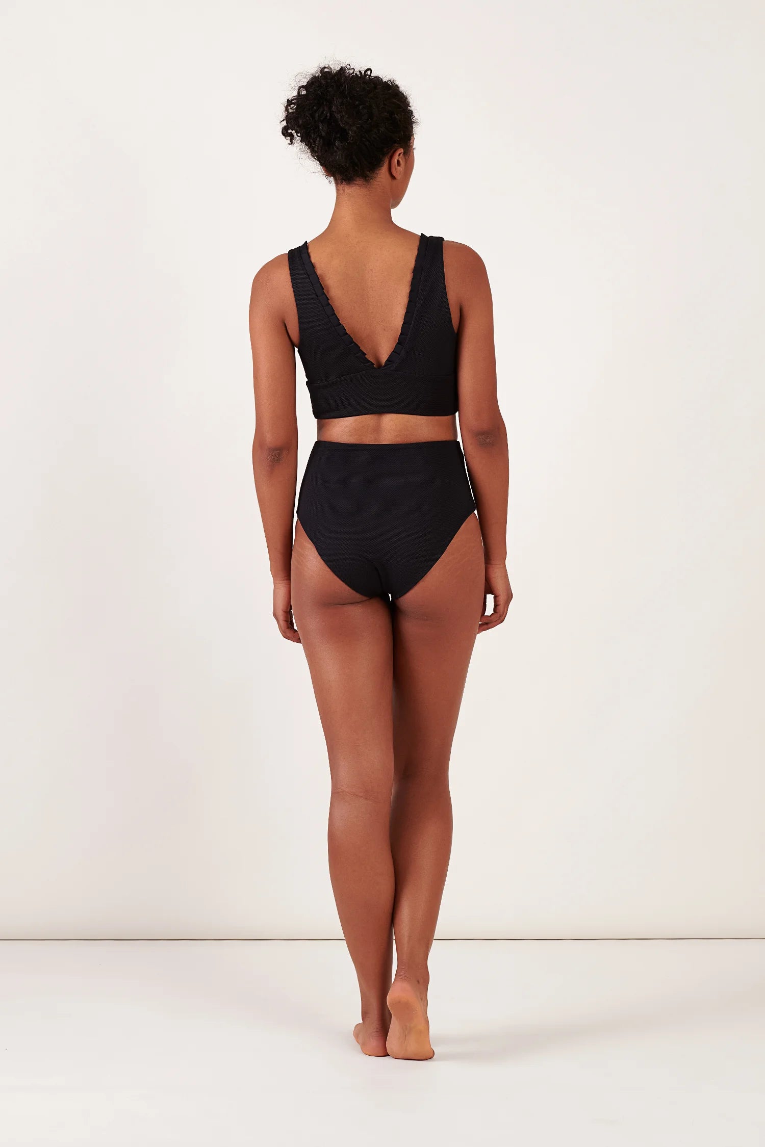 Schwarzes Bikinitop mit V-Ausschnitt und breiten Trägern sowie passende hohe Bikinihose von MYMARINI, von hinten sichtbar.#color_black