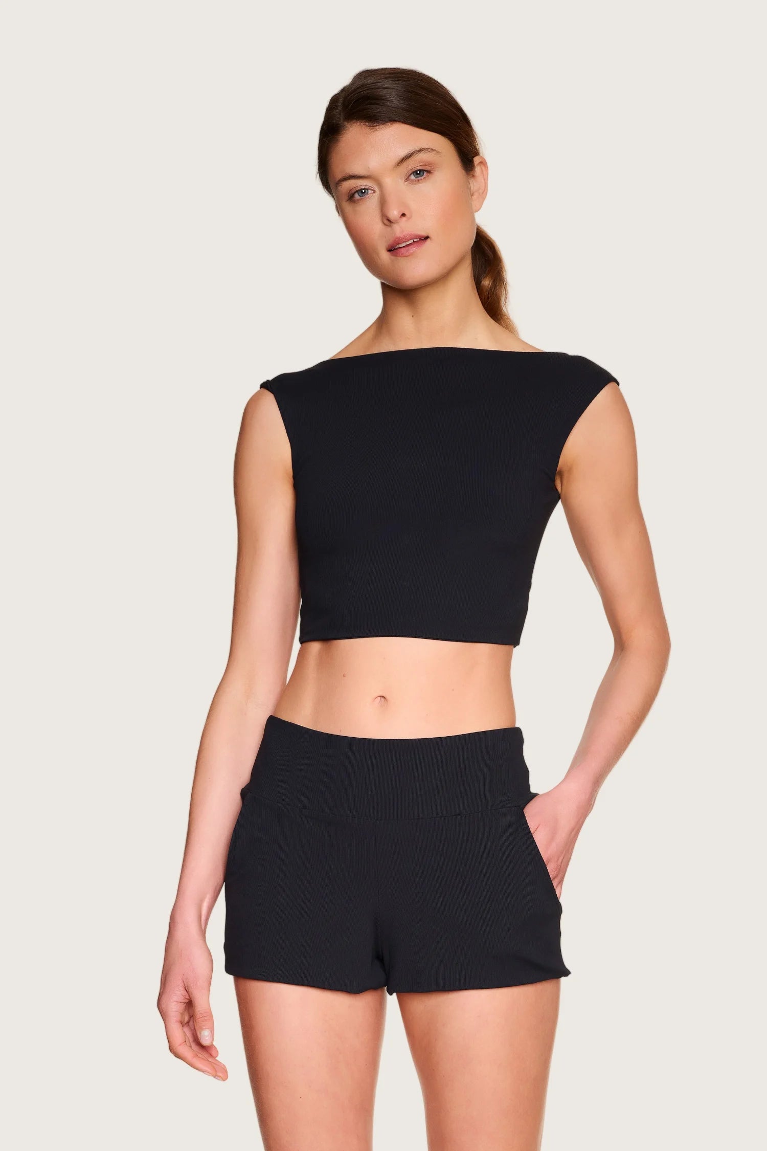 Frau trägt schwarzes MYMARINI-Top mit breiten Trägern und passende Shorts.#color_black