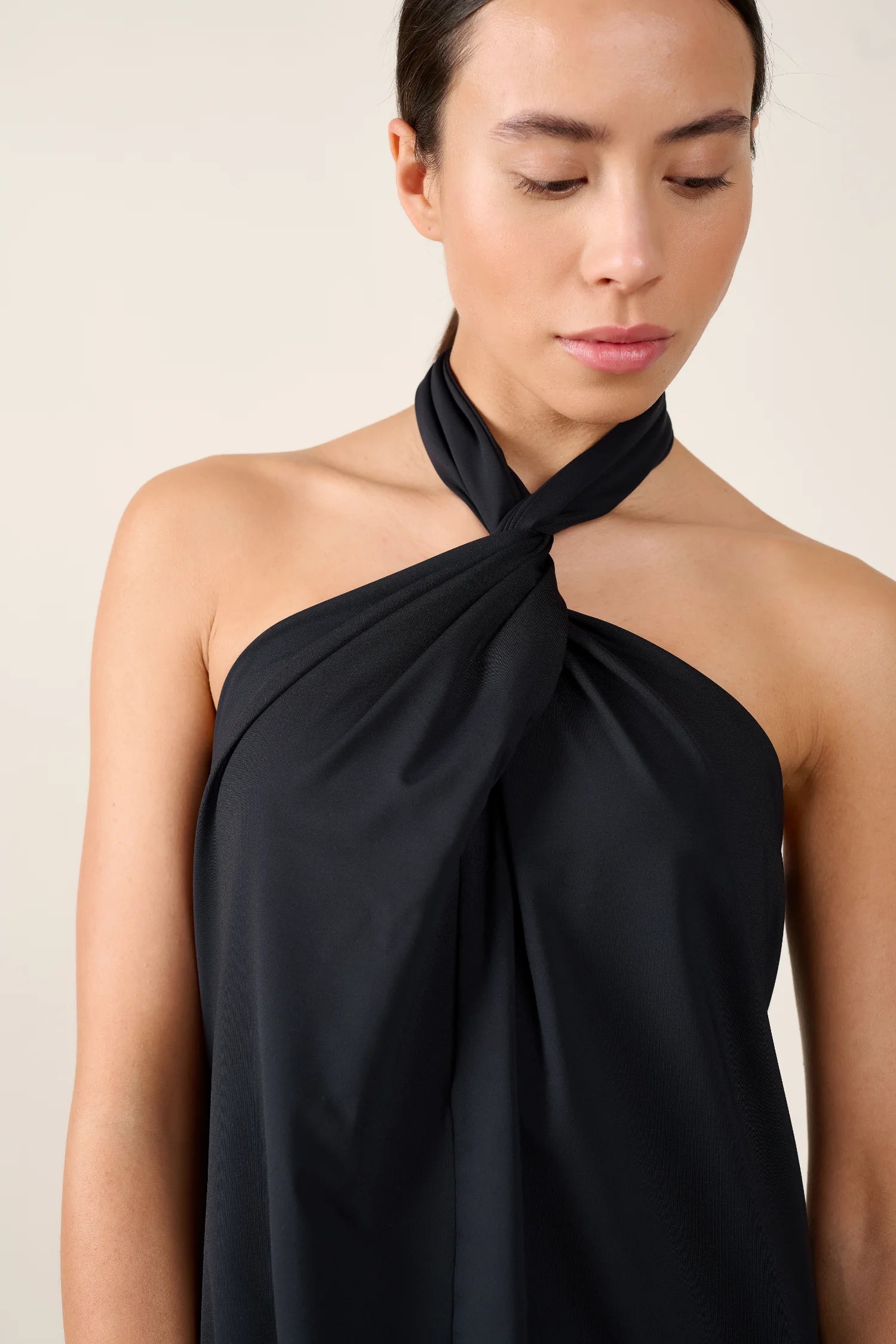 Person trägt ein schwarzes Neckholder-Top von MYMARINI.#color_black