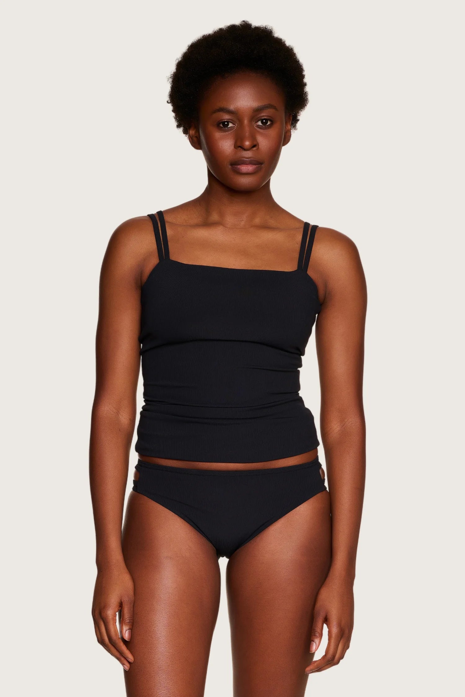 Frau trägt MYMARINI Bikinitop mit quadratischem Ausschnitt und schmalen Trägern, kombiniert mit passender Bikinihose.#color_black