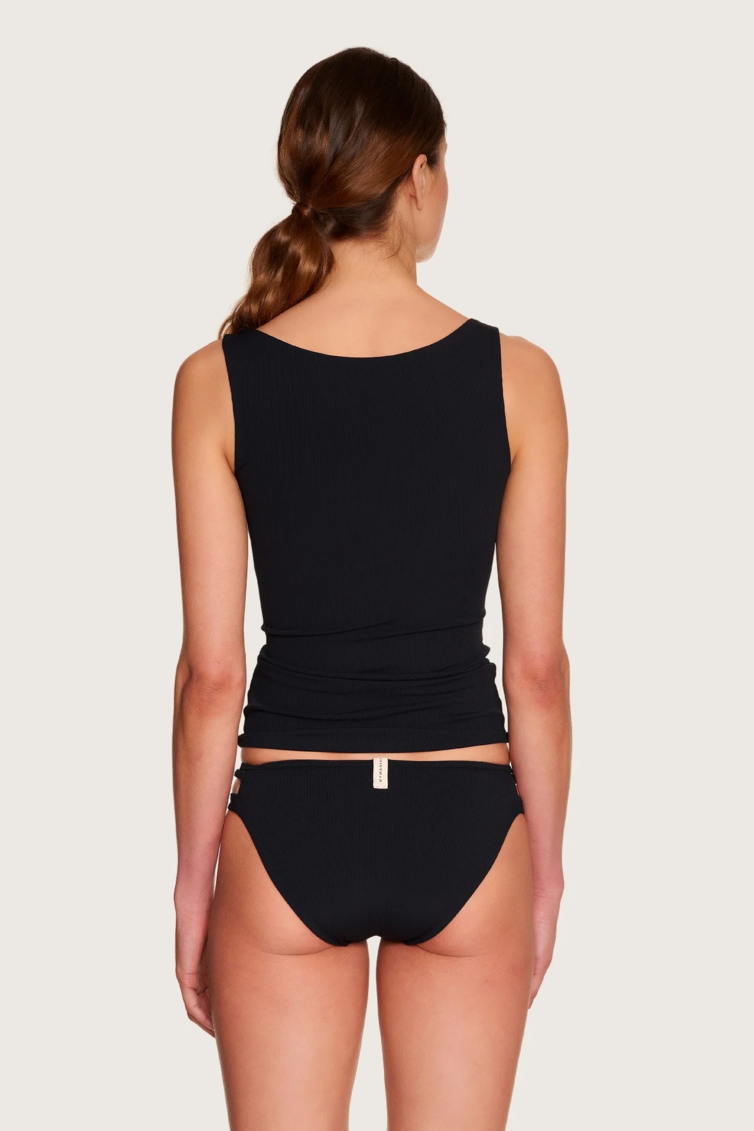 Rückansicht einer Frau in schwarzem MYMARINI-Top mit breiten Trägern und Bikinihose mit hohem Beinausschnitt.#color_black