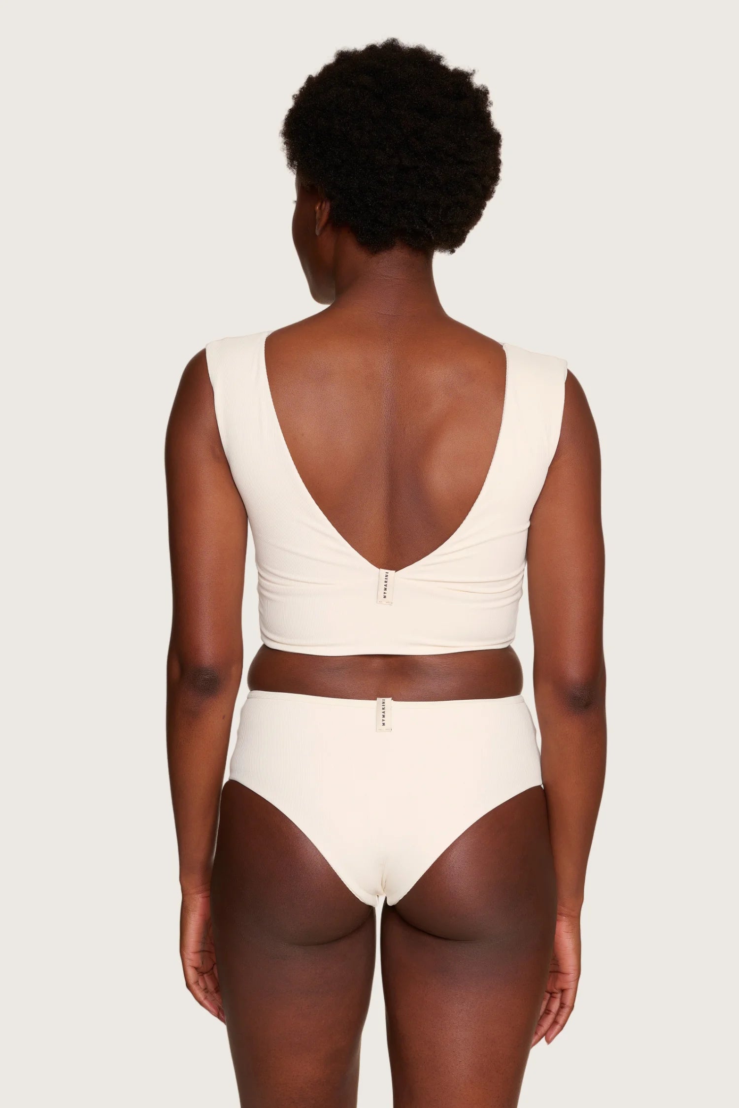 Rückansicht eines MYMARINI Bikinitops mit tiefem Rückenausschnitt und breiten Trägern in Cremeweiß.#color_off-white