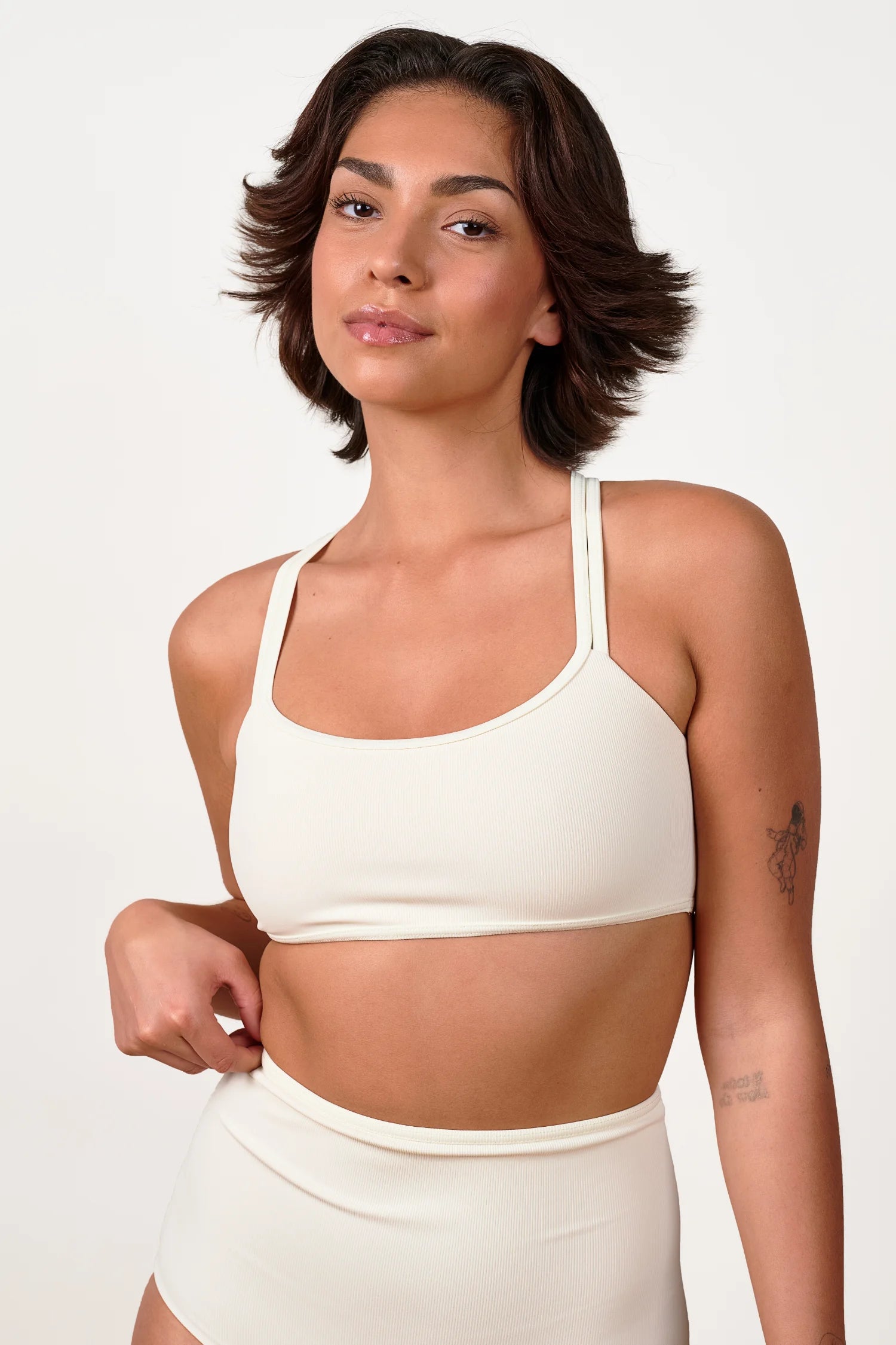 Frau trägt MYMARINI Bikinitop mit breiten Trägern und Bikinihose in High Waist.#color_off-white