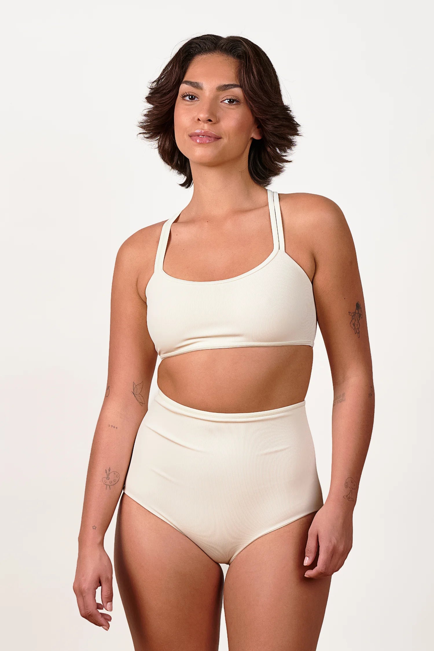 Frau trägt MYMARINI Bikinitop mit breiten Trägern und Bikinihose in High Waist.#color_off-white