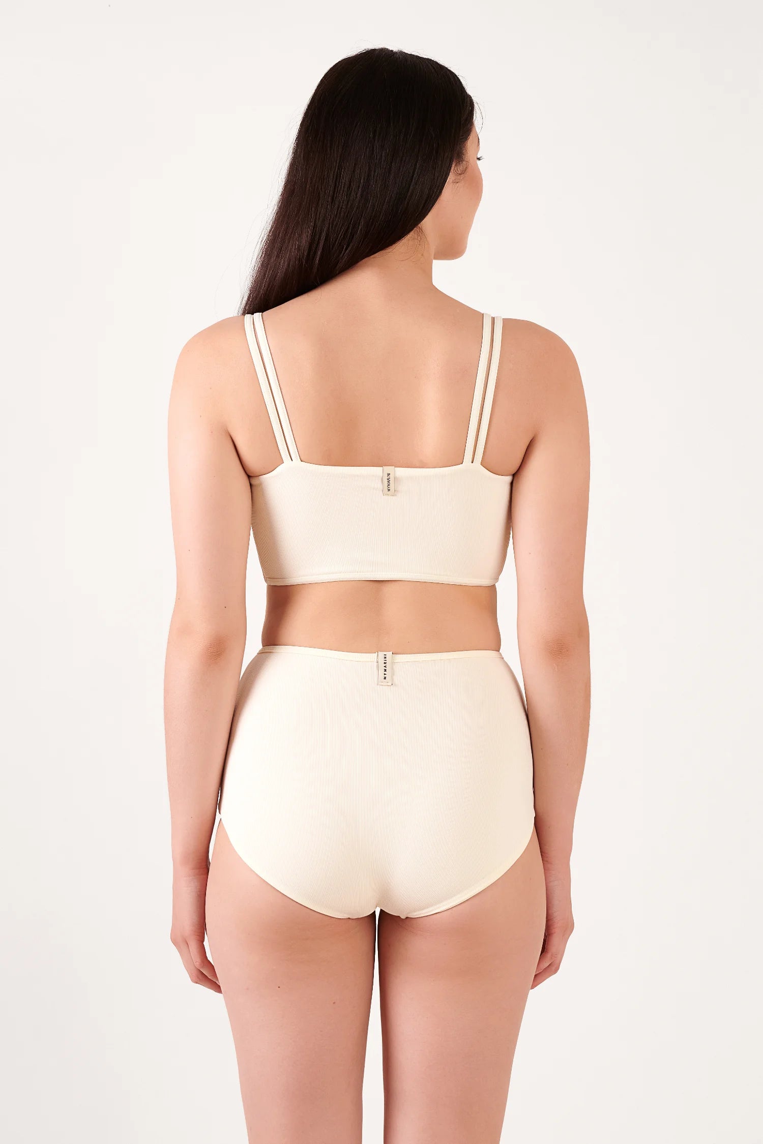 Bikinitop und Bikinihose von MYMARINI in hellem Beige, hochgeschlossen mit breiten Trägern, von hinten fotografiert.#color_white