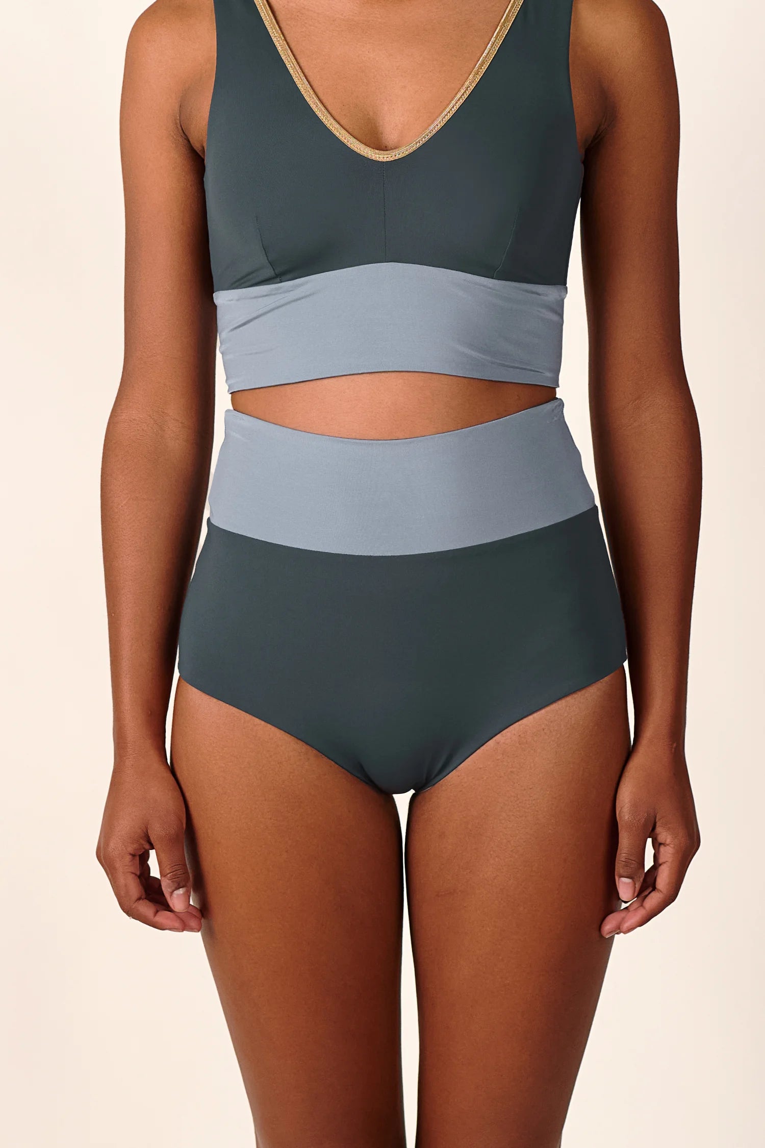 Frau trägt MYMARINI Bikini mit V-Ausschnitt und High Waist Hose in Dunkelgrün und Grau.#color_crystal-grey
