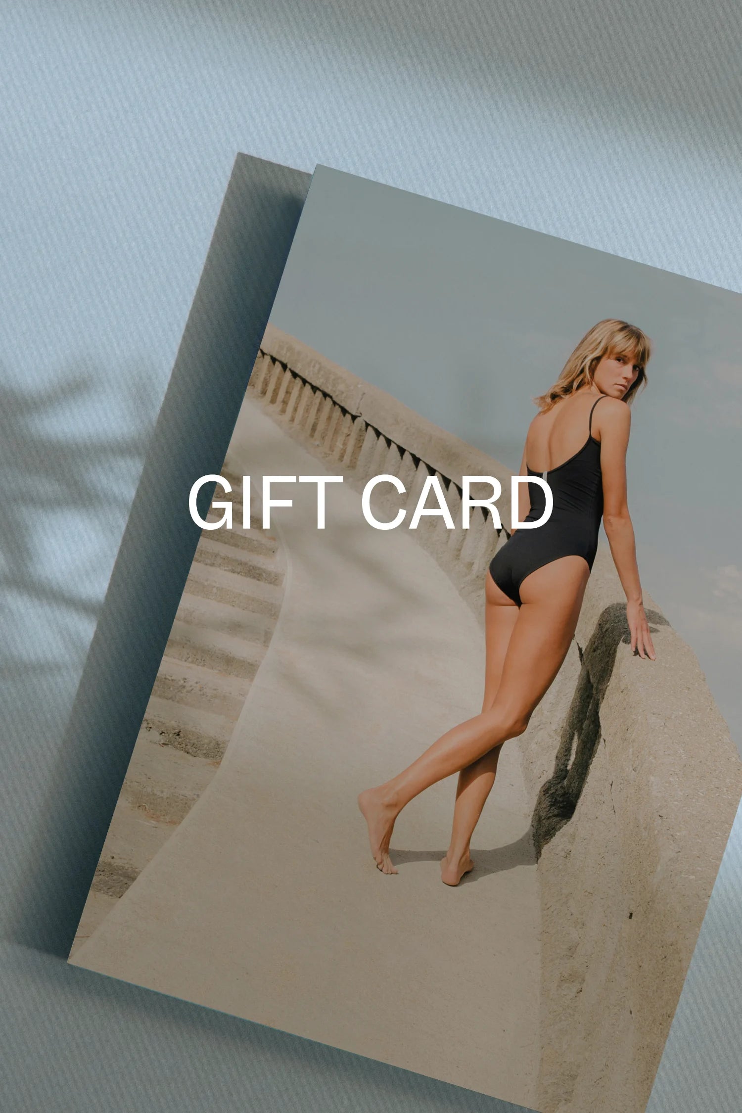 Digitaler MYMARINI Geschenkgutschein mit dem Schriftzug “GIFT CARD” und Fotoprint einer Frau im Badeanzug.