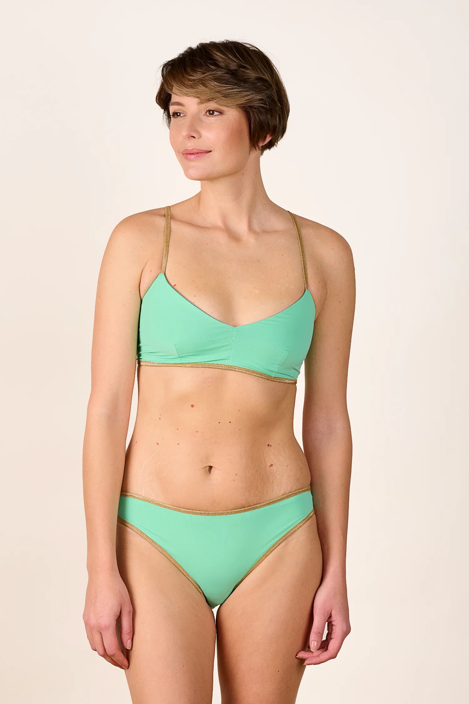 Frau trägt MYMARINI Bikini mit V-Ausschnitt und Spaghettiträgern in Mintgrün.#color_lagoon-teal