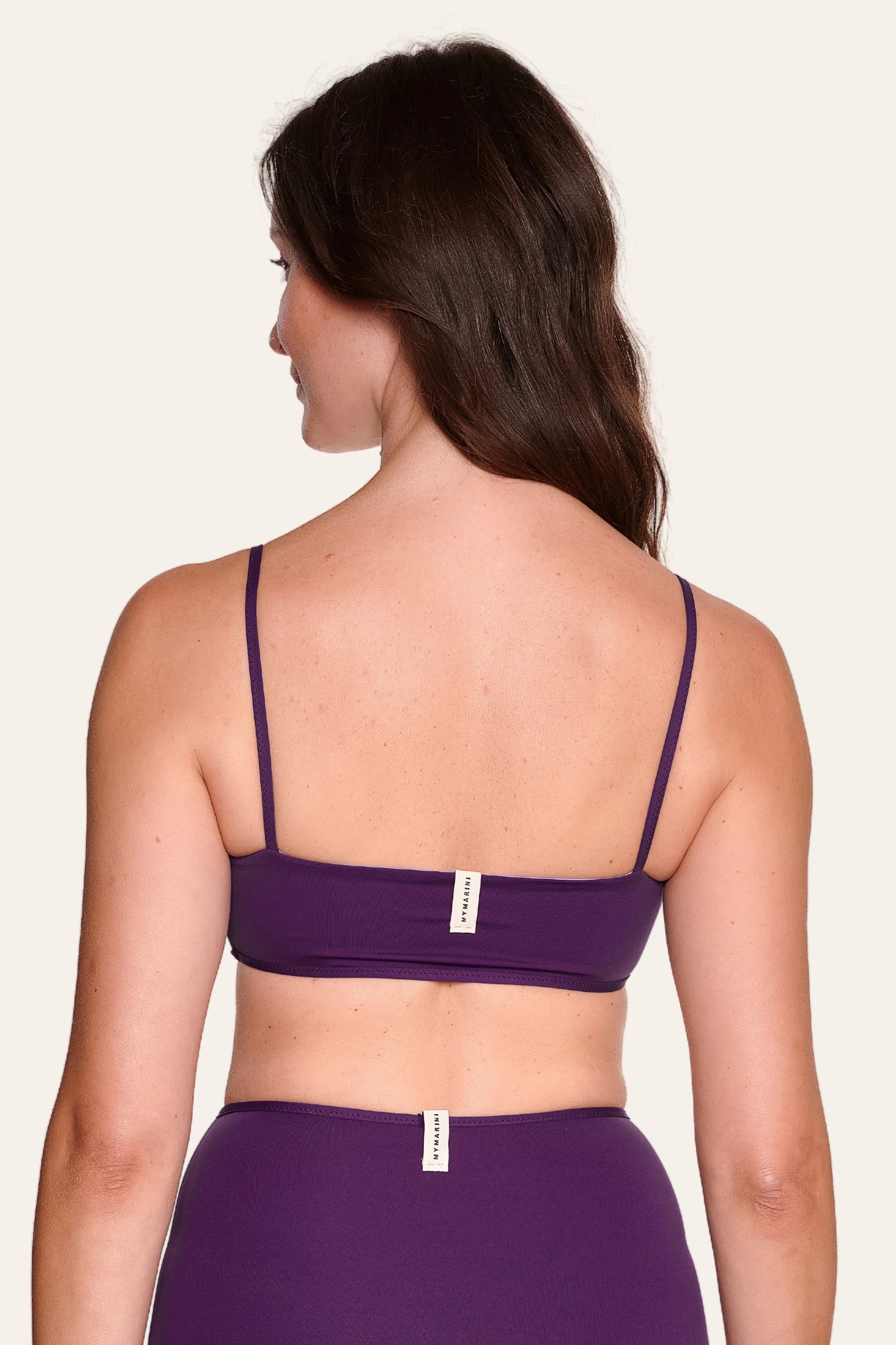Frau in lila MYMARINI Bikinitop mit Spaghettiträgern und passender Bikinihose, Rückansicht.#color_lavender-plum