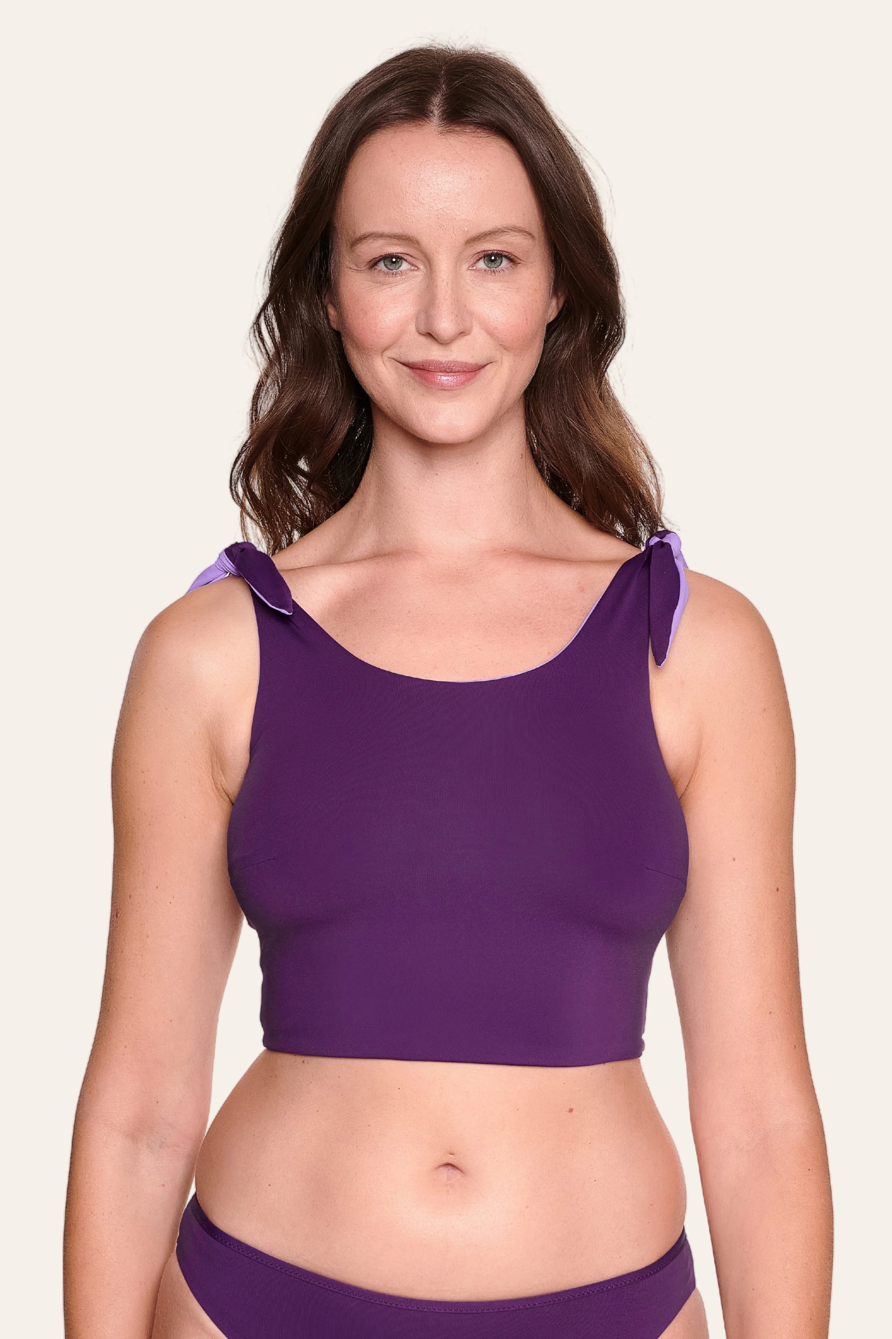 Frau trägt lila MYMARINI Bikinitop mit breiten Trägern und passender Bikinihose.#color_lavender-plum