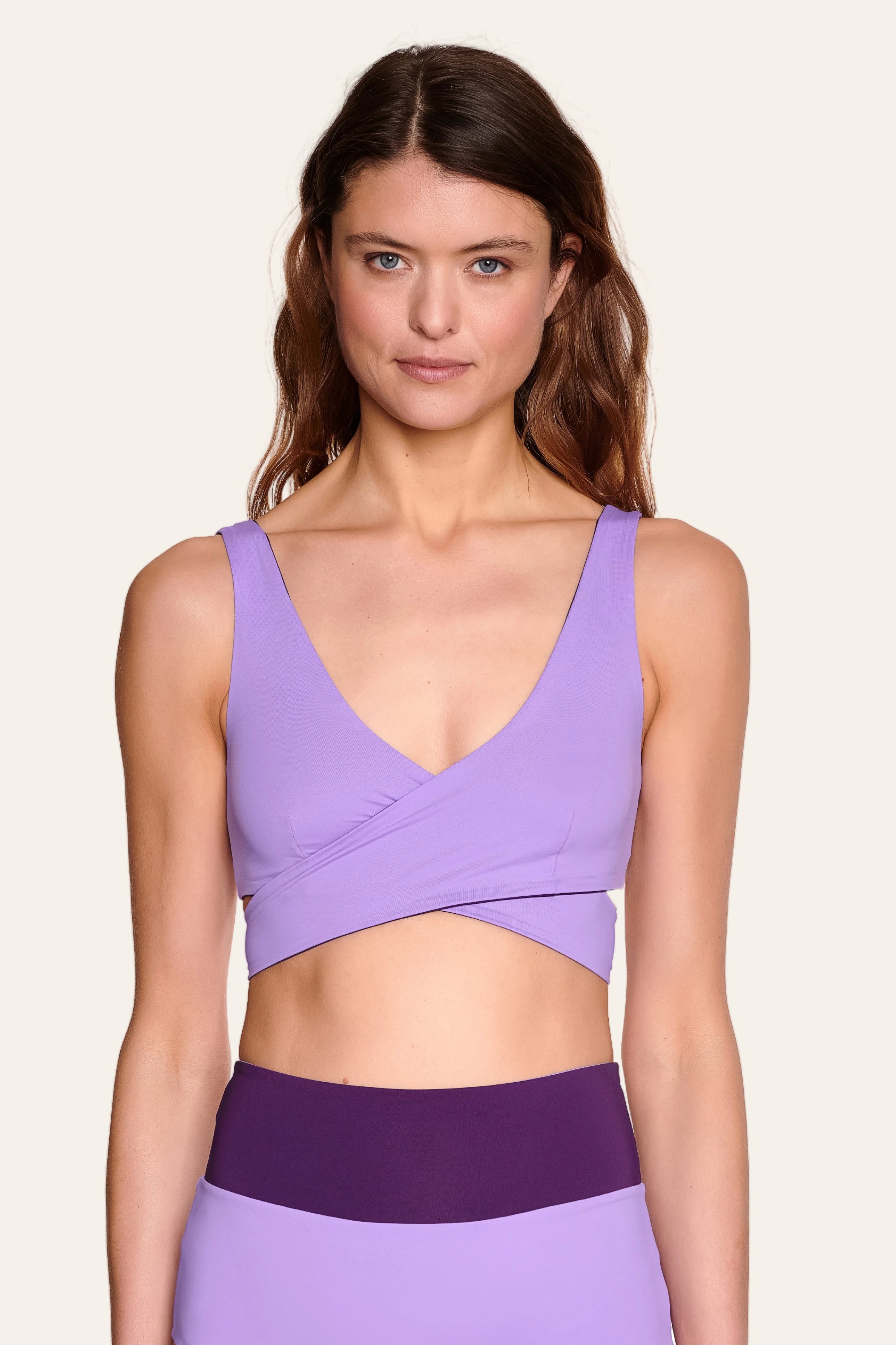 Frau trägt MYMARINI Bikinitop mit V-Ausschnitt und breiten Trägern in Lila.#color_lavender-plum