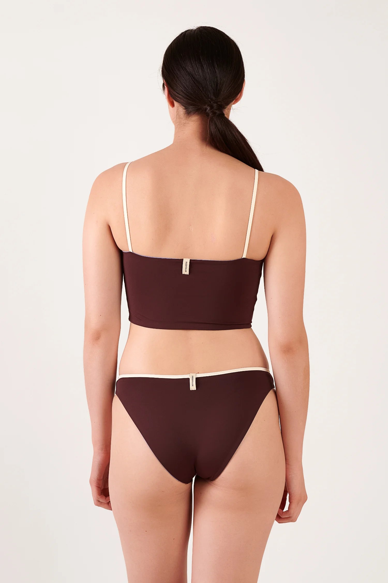 MYMARINI Bikini: braunes Oberteil mit cremefarbenen Spaghettiträgern und passende Hose mit Rand; Rückenansicht, Markenetikett sichtbar.#color_chocolate-lilac