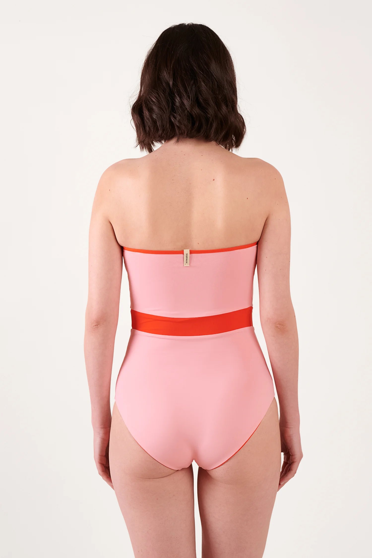 MYMARINI One-Piece-Badeanzug in Rosa mit orangem Band, Rückenansicht, Bandeau-Schnitt, kleines Markenschild.#color_poppy-macaron