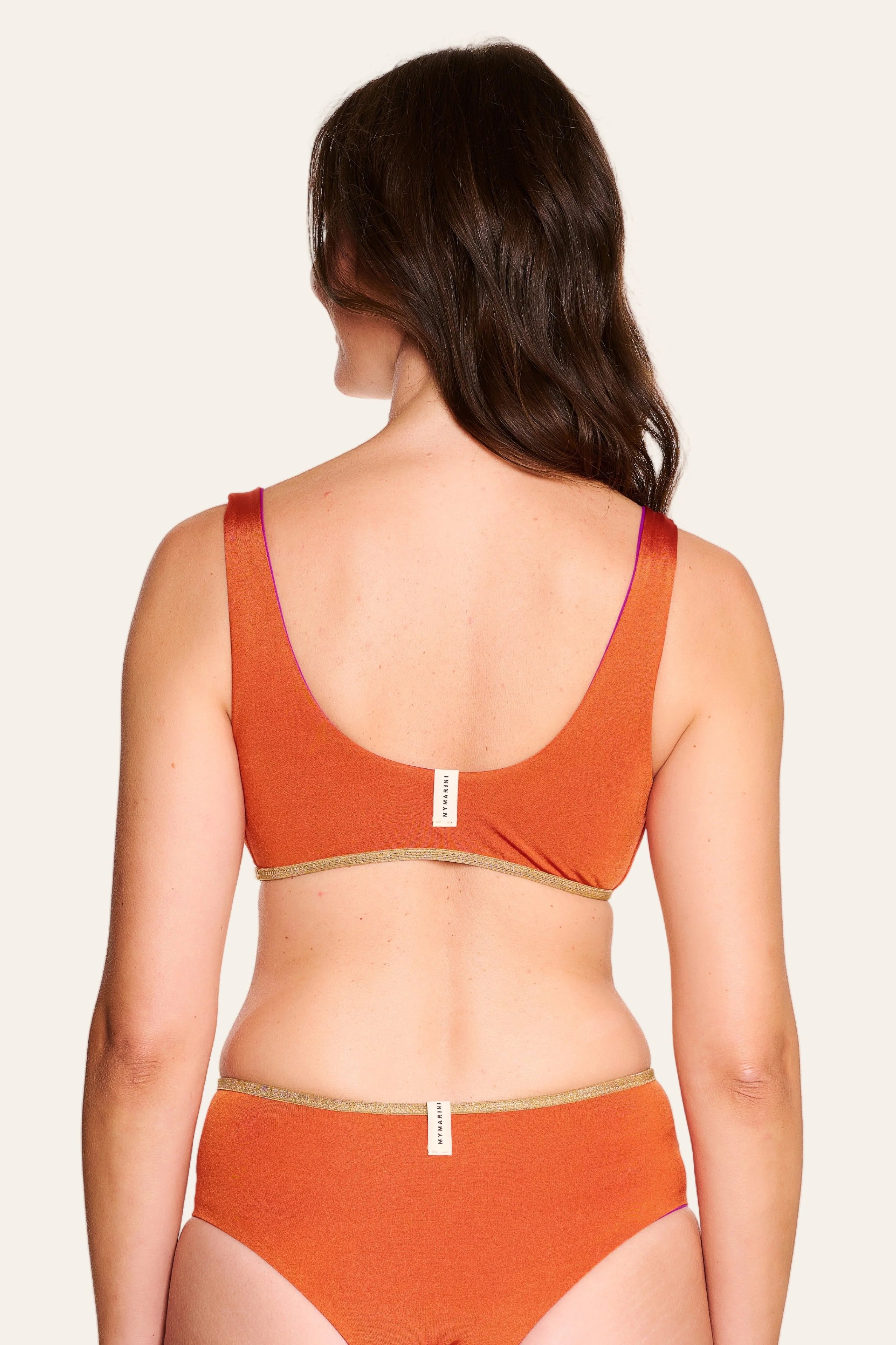 Rückansicht eines MYMARINI Bikinitops mit breiten Trägern und einer Bikinihose in Orange, beide mit hohem Beinausschnitt.#color_papaya-cassis