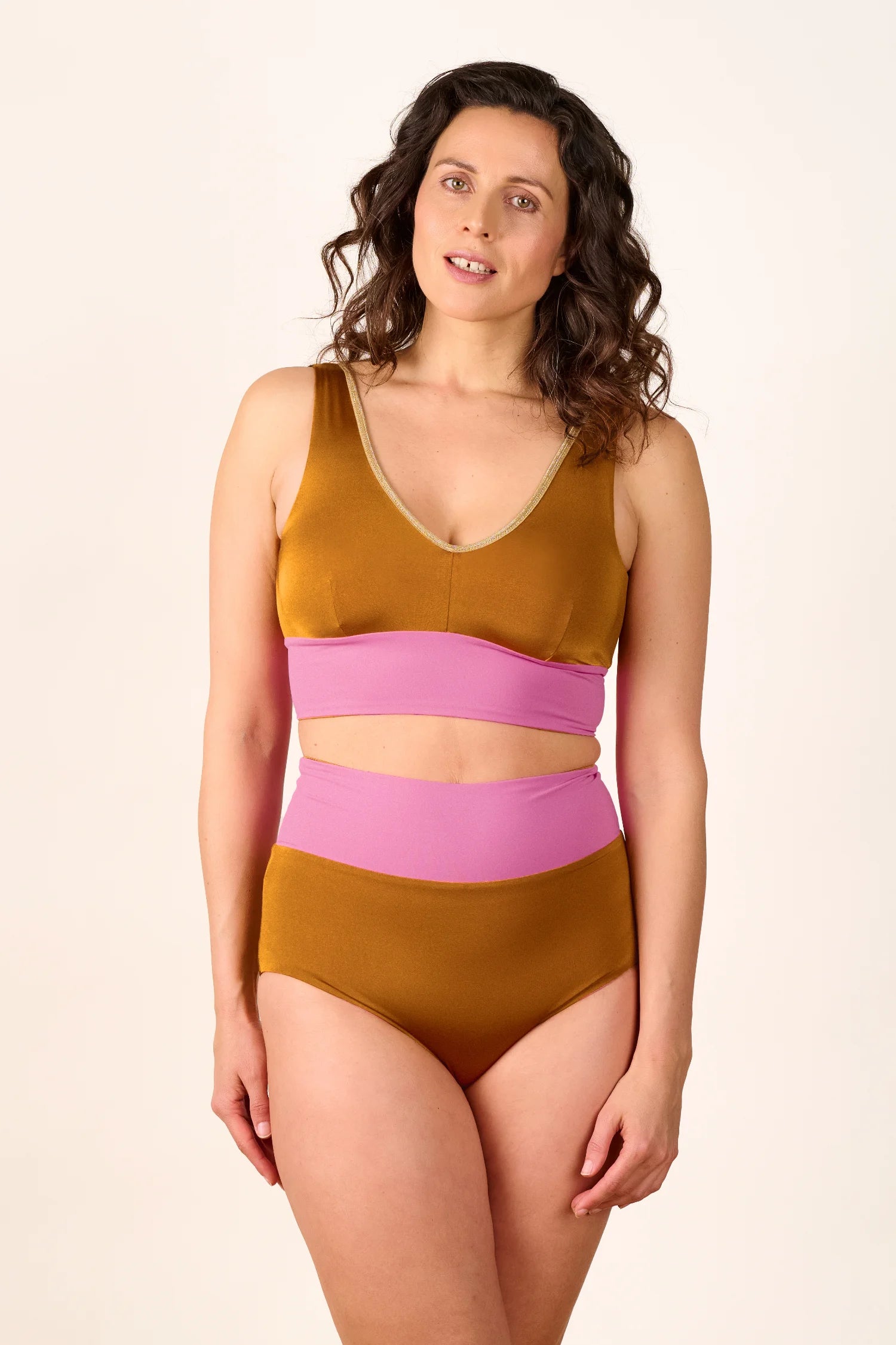 Frau trägt MYMARINI Bikini mit V-Ausschnitt und High Waist in Braun und Rosa.#color_bronze-orchid