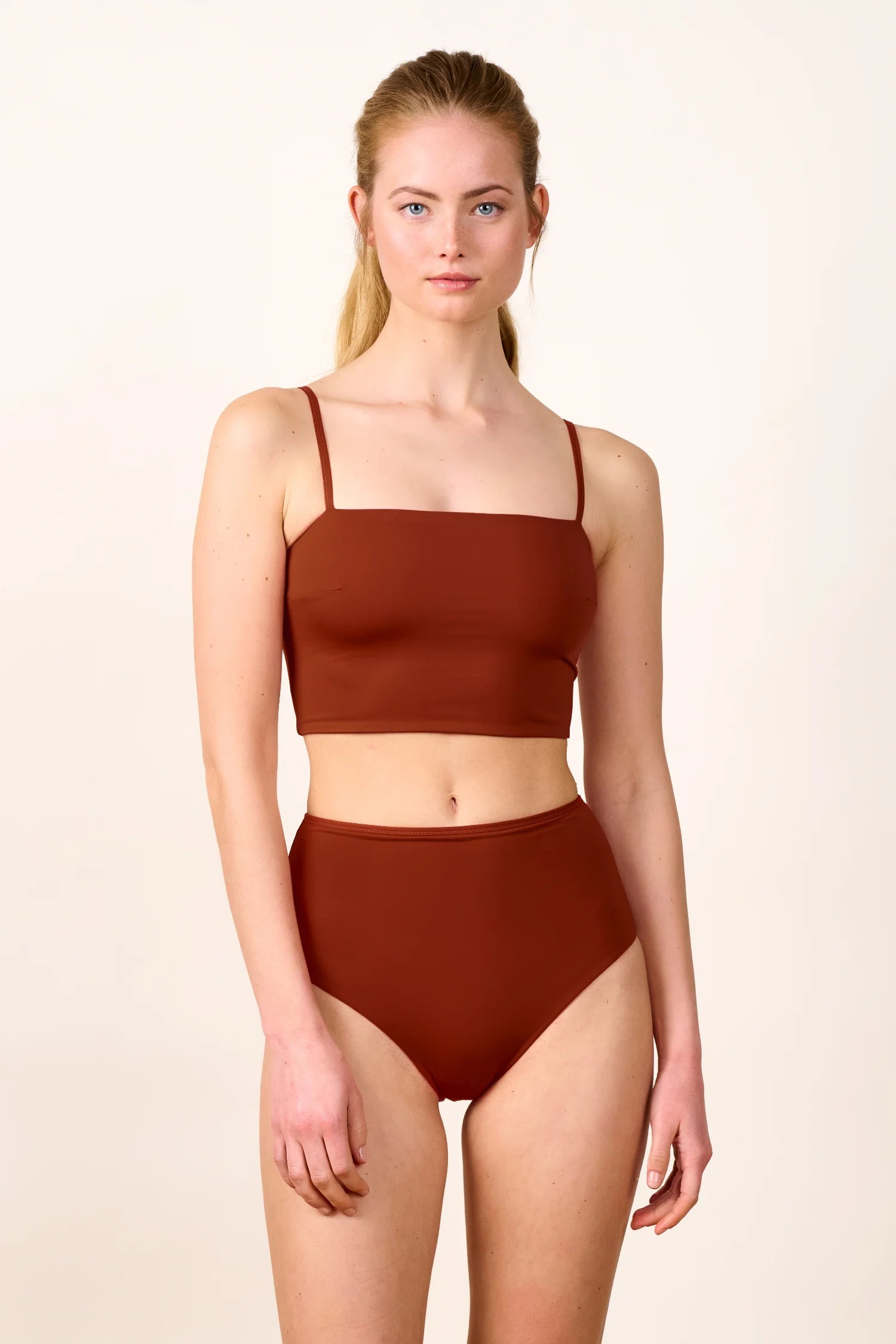 Frau trägt MYMARINI Bikini mit Spaghettiträgern und High-Waist-Schnitt in Braun.#color_sienna-orchid