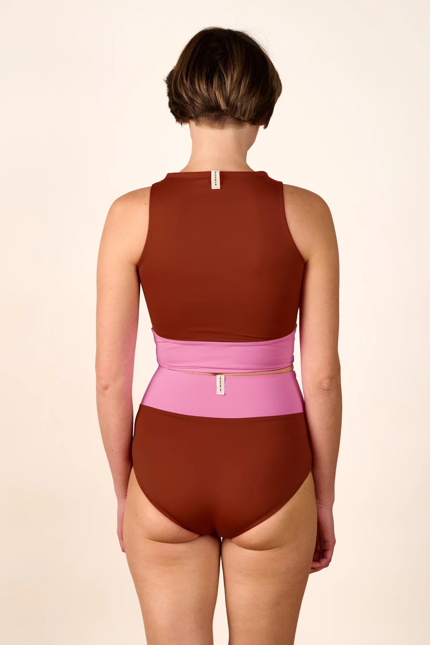 Rückansicht eines MYMARINI Badeanzugs mit breiten Trägern und hohem Beinausschnitt in Braun und Rosa.#color_sienna-orchid