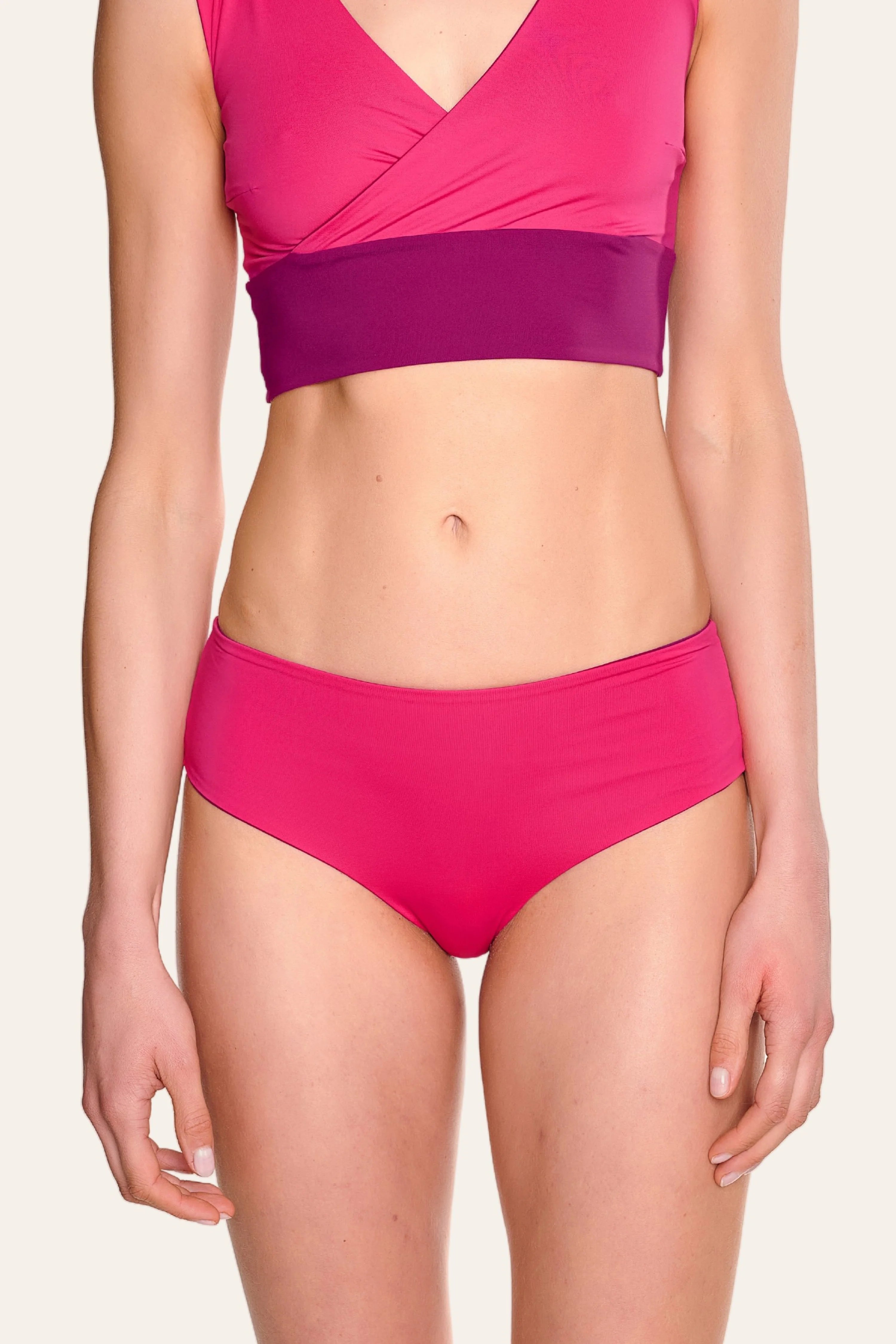 Frau trägt MYMARINI Bikinitop mit V-Ausschnitt und Bikinihose in Pink.#color_pink-hortensia