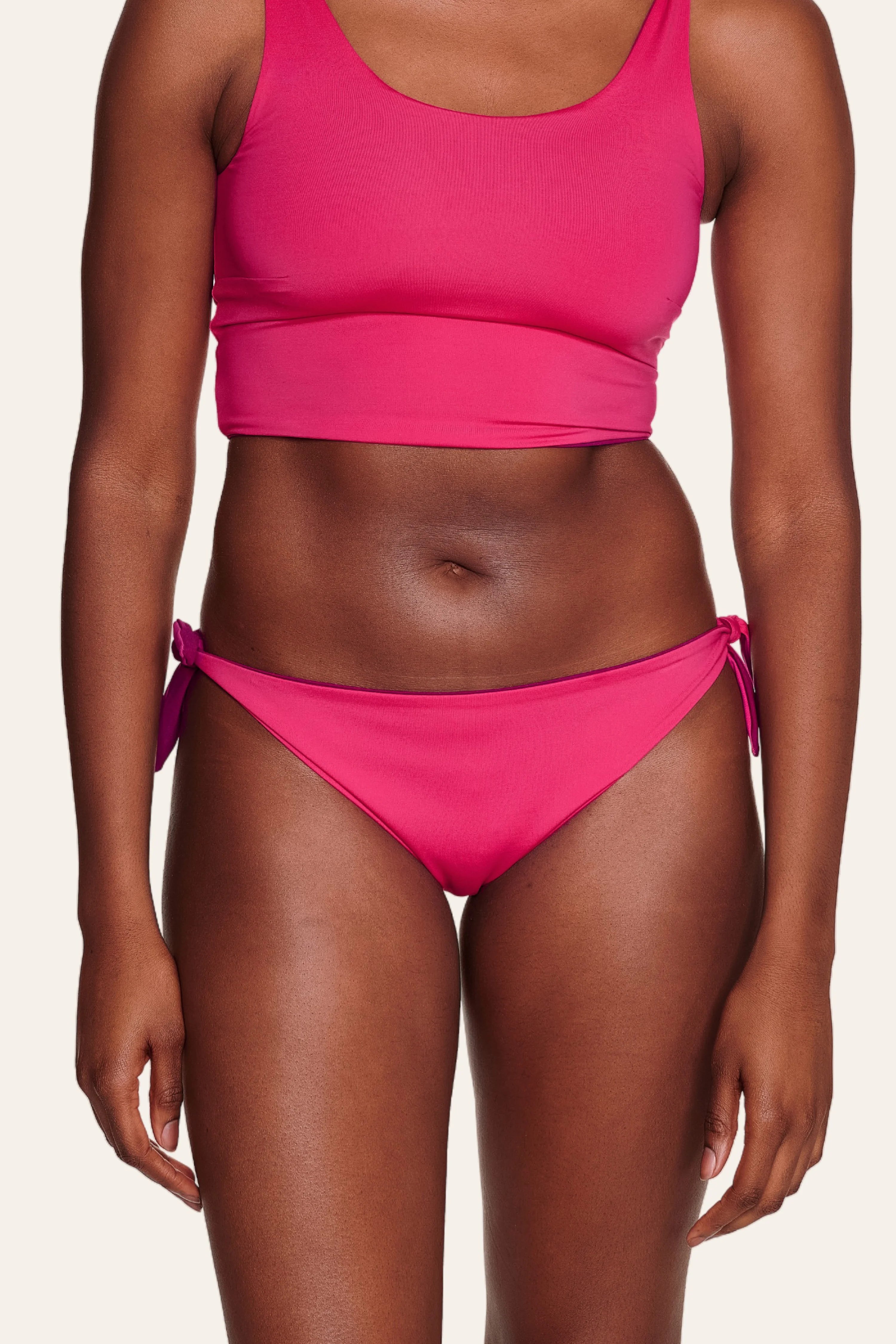 Frau trägt MYMARINI Bikinitop mit breiten Trägern und Bikinihose mit seitlichen Schleifen in Pink.#color_pink-hortensia