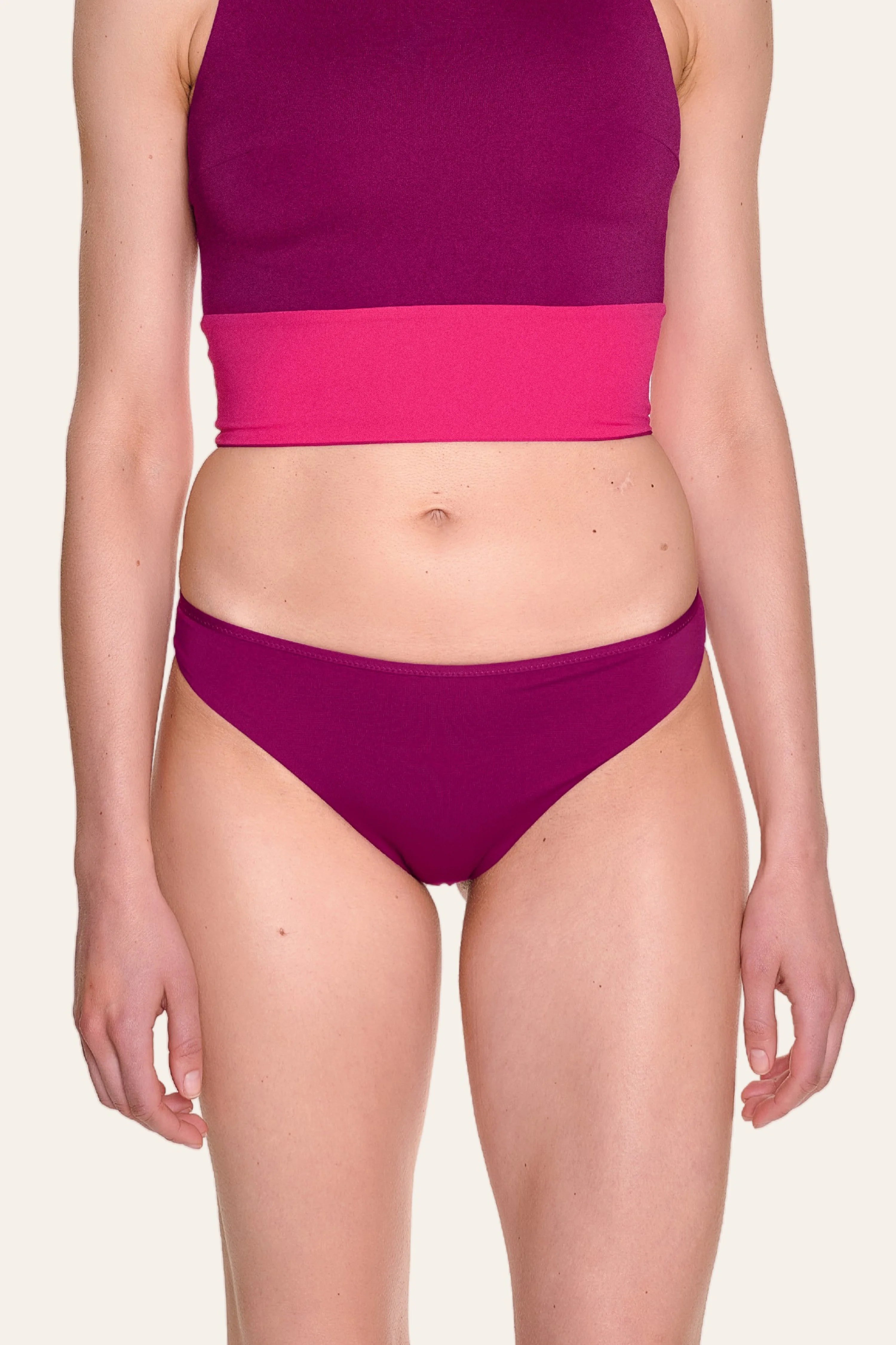 Person trägt MYMARINI Bikinitop mit hoch geschlossenem Schnitt und Bikinihose mit tiefem Beinausschnitt in Pinktönen.#color_pink-hortensia