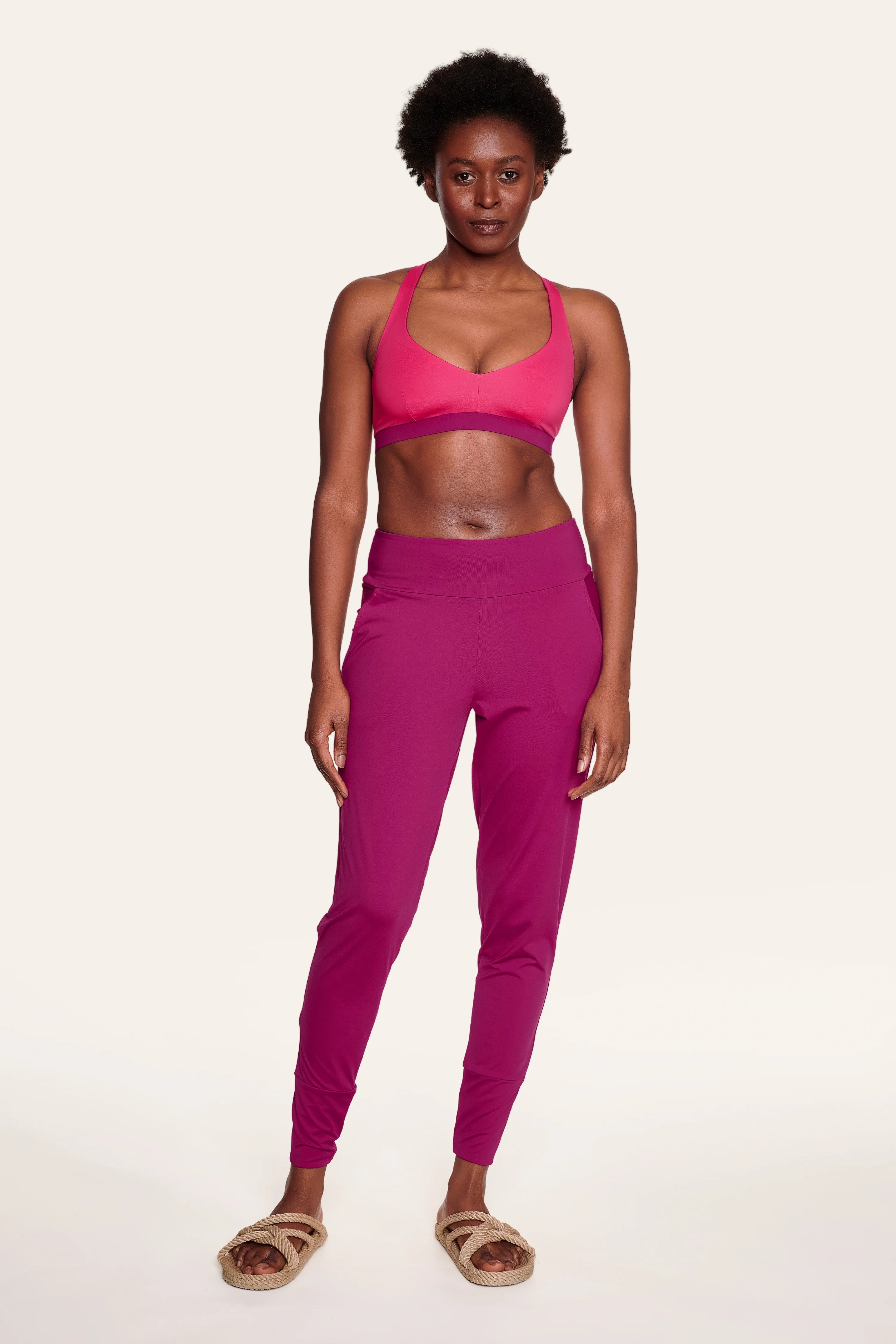 Frau trägt MYMARINI Bikinitop mit V-Ausschnitt und Hose in Pink.#color_hortensia