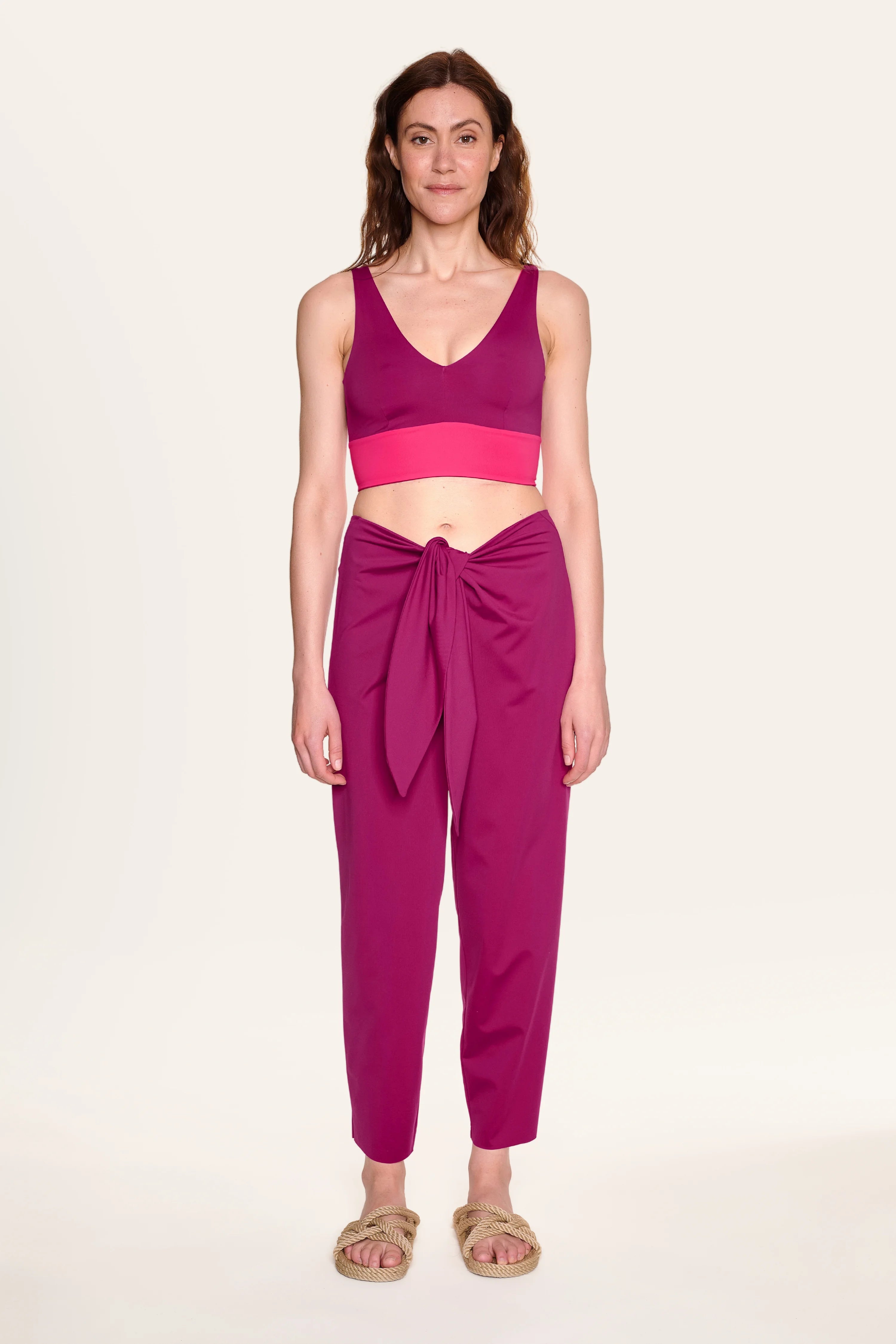 Frau trägt MYMARINI Bikinitop mit V-Ausschnitt und Hose in Pink.#color_hortensia