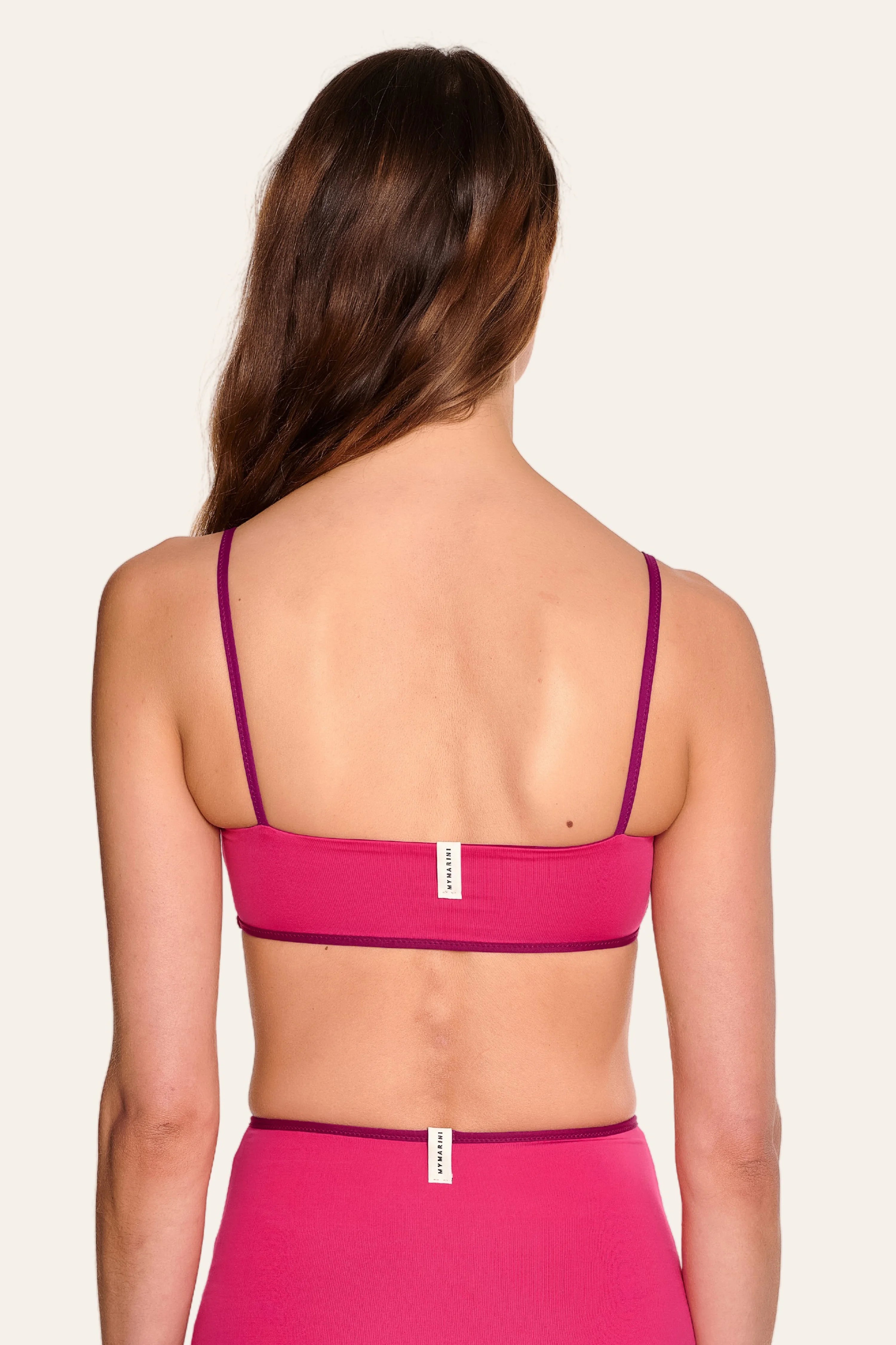 Rückansicht einer Frau in einem pinken MYMARINI Bikinitop mit Spaghettiträgern und passender Bikinihose.#color_pink-hortensia