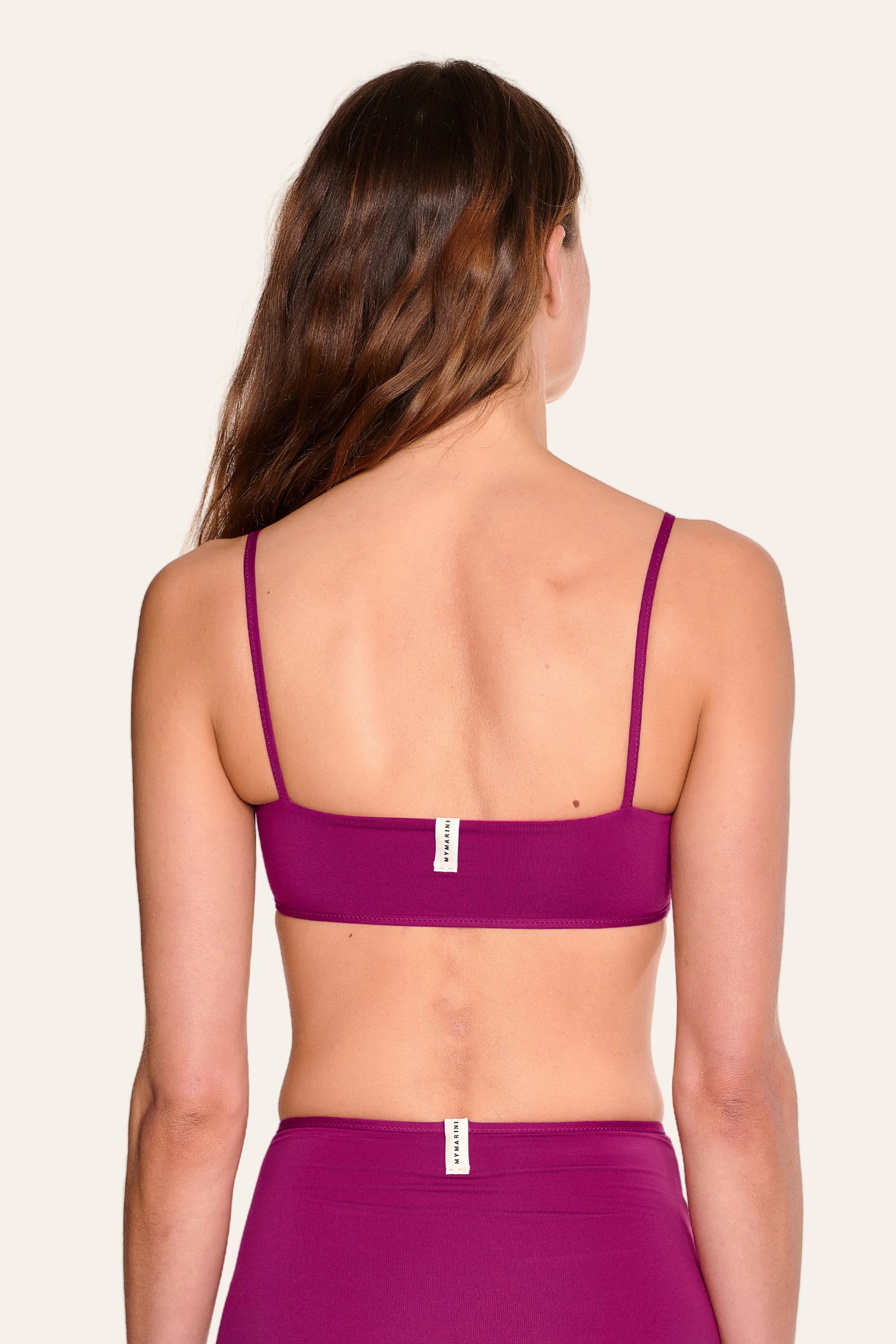 Rückansicht eines MYMARINI Bikinitops mit Spaghettiträgern und einer Bikinihose in Magenta, beide hoch geschnitten.#color_pink-hortensia