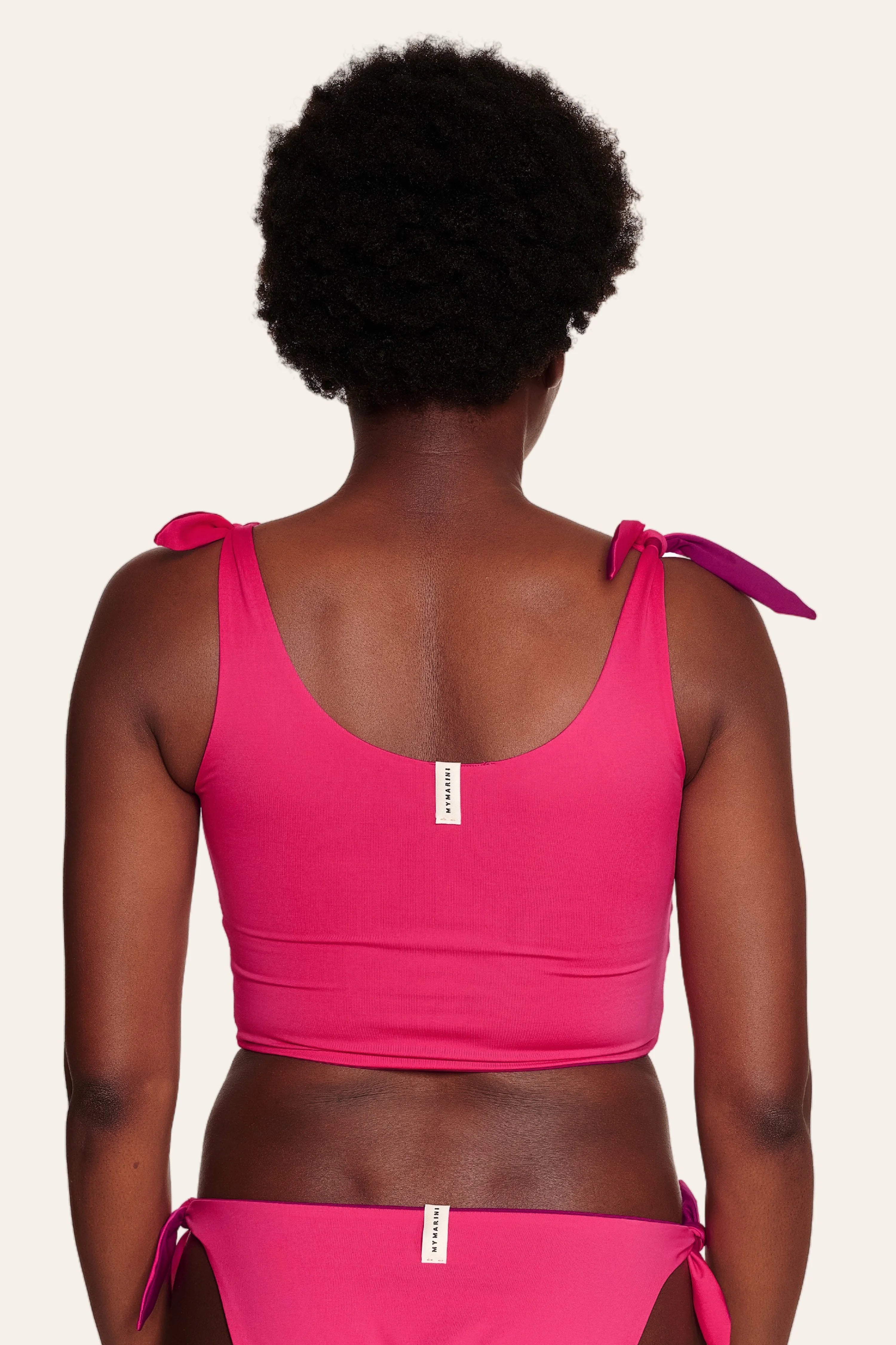Rückansicht einer Person in pinkem MYMARINI Bikinitop mit breiten Trägern und passender Bikinihose.#color_pink-hortensia