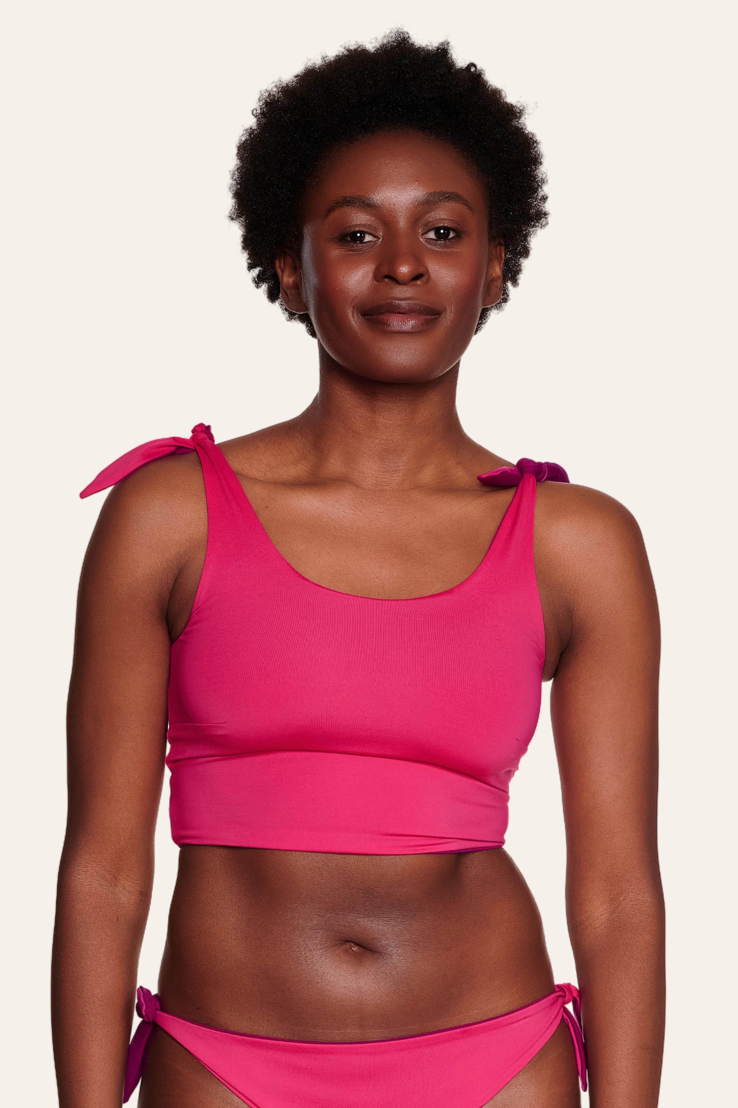 Frau trägt ein pinkes MYMARINI Bikinitop mit breiten Trägern und passender Bikinihose.#color_pink-hortensia
