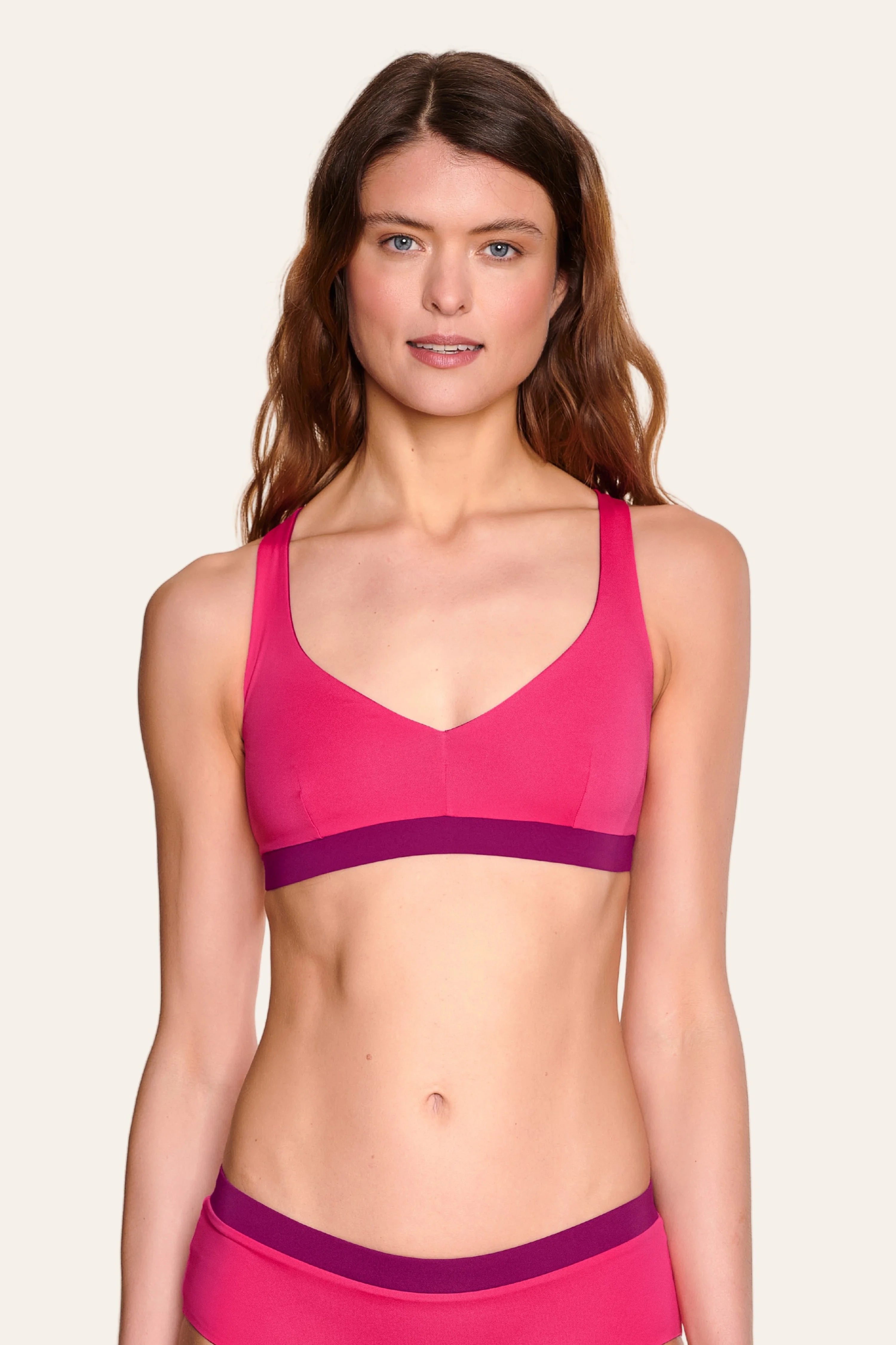 Frau trägt MYMARINI Bikinitop mit V-Ausschnitt und breiten Trägern in Pink.#color_pink-hortensia