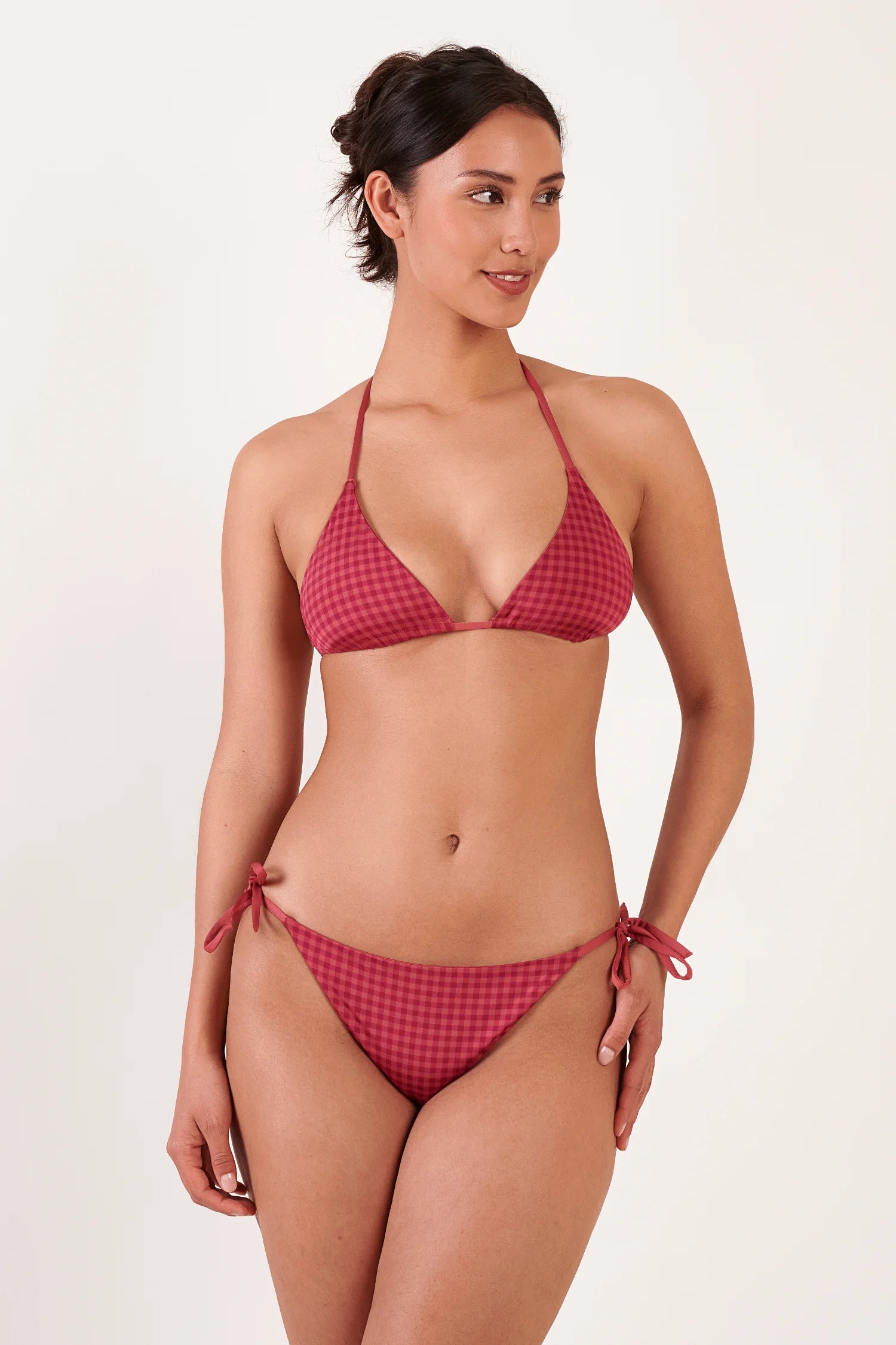 MYMARINI Bikini: Frau in rotem Karo-Triangle-Halteroberteil und passender Bikini-Hose mit seitlichen Bindebändern.#color_rouge-vichy