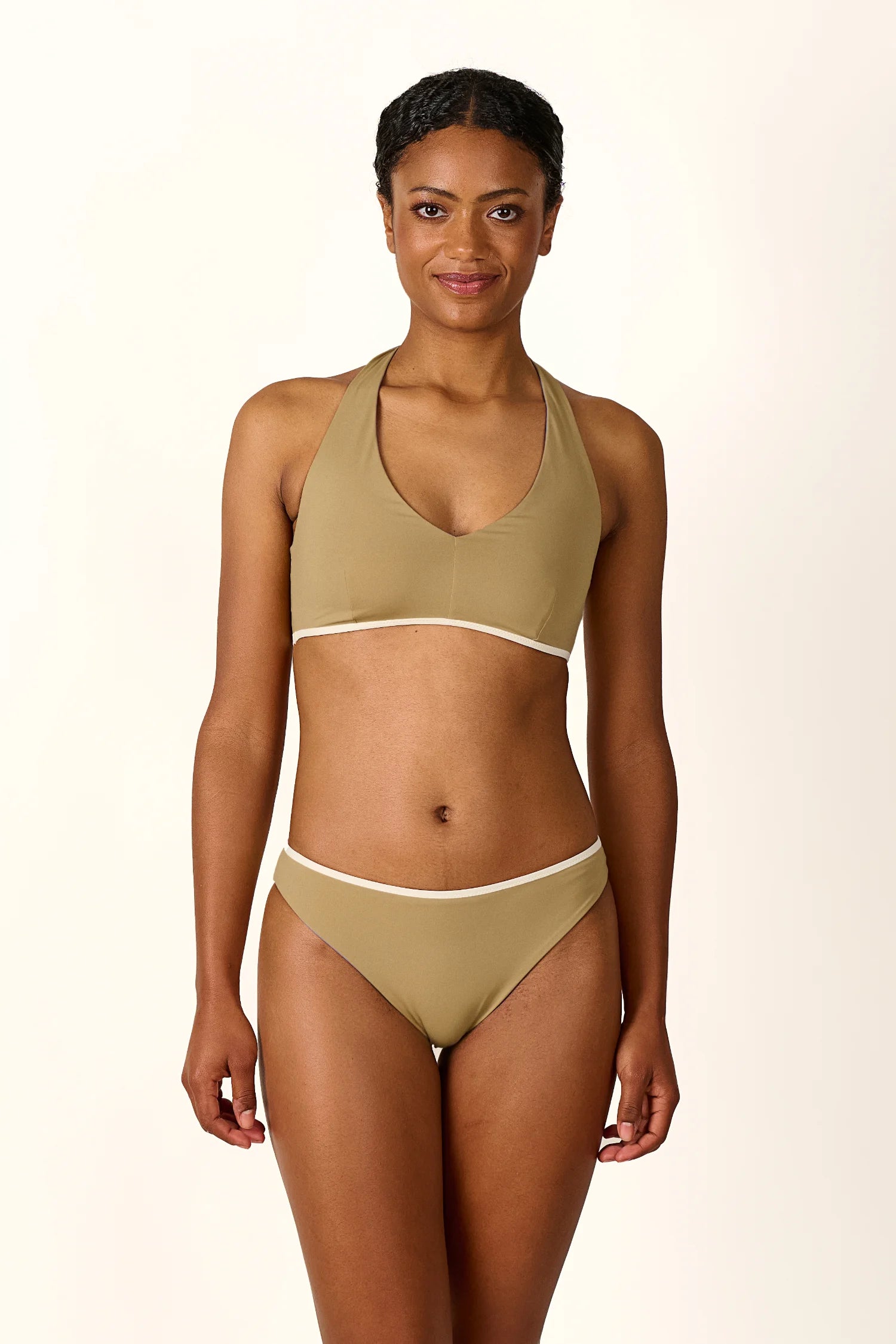Frau trägt MYMARINI Bikini mit Neckholder-Top und Mid rise Hose in Beige.#color_coast-desert