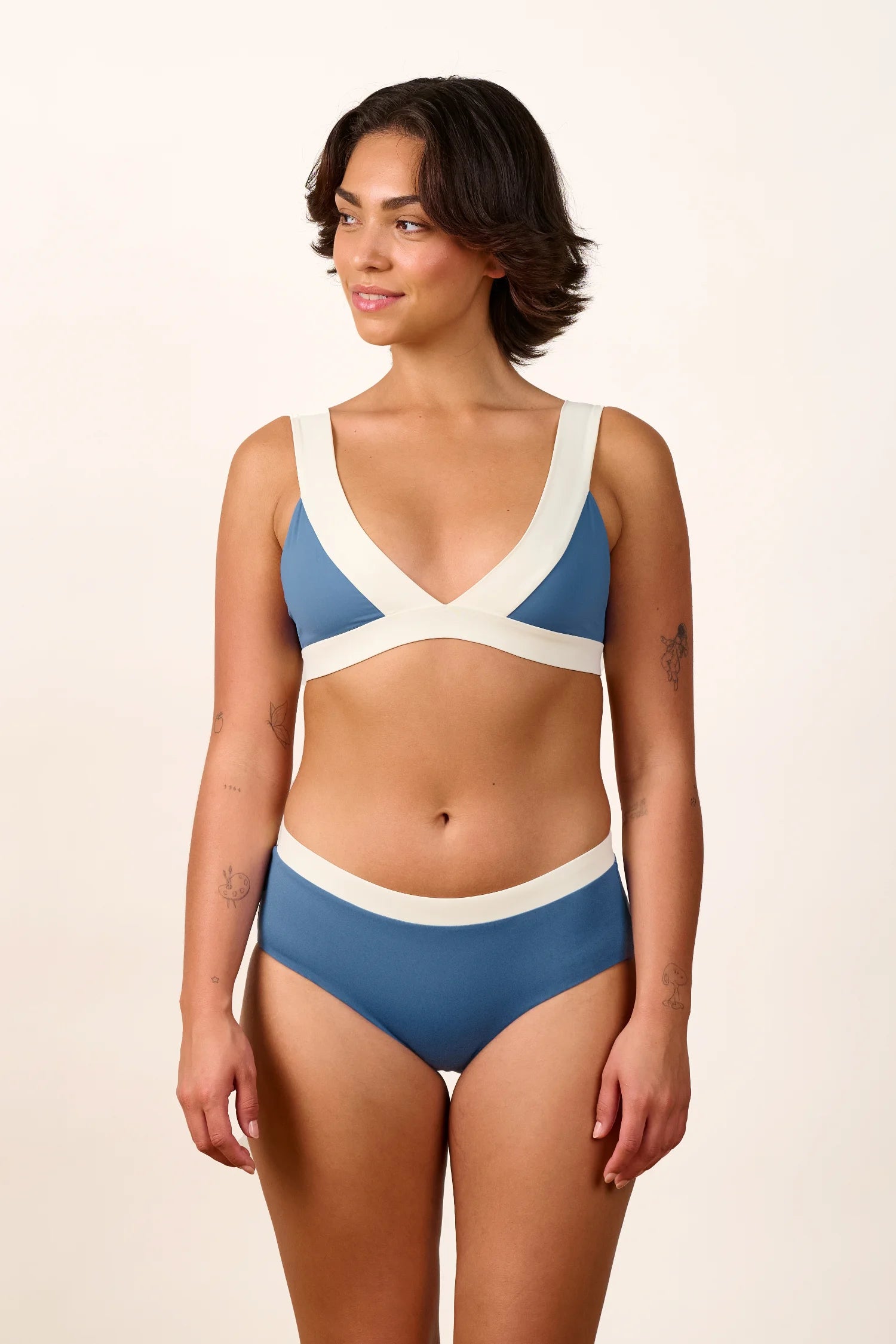 Frau trägt MYMARINI Bikini mit V-Ausschnitt und breiten Trägern in Blau und Weiß.#color_coast-desert