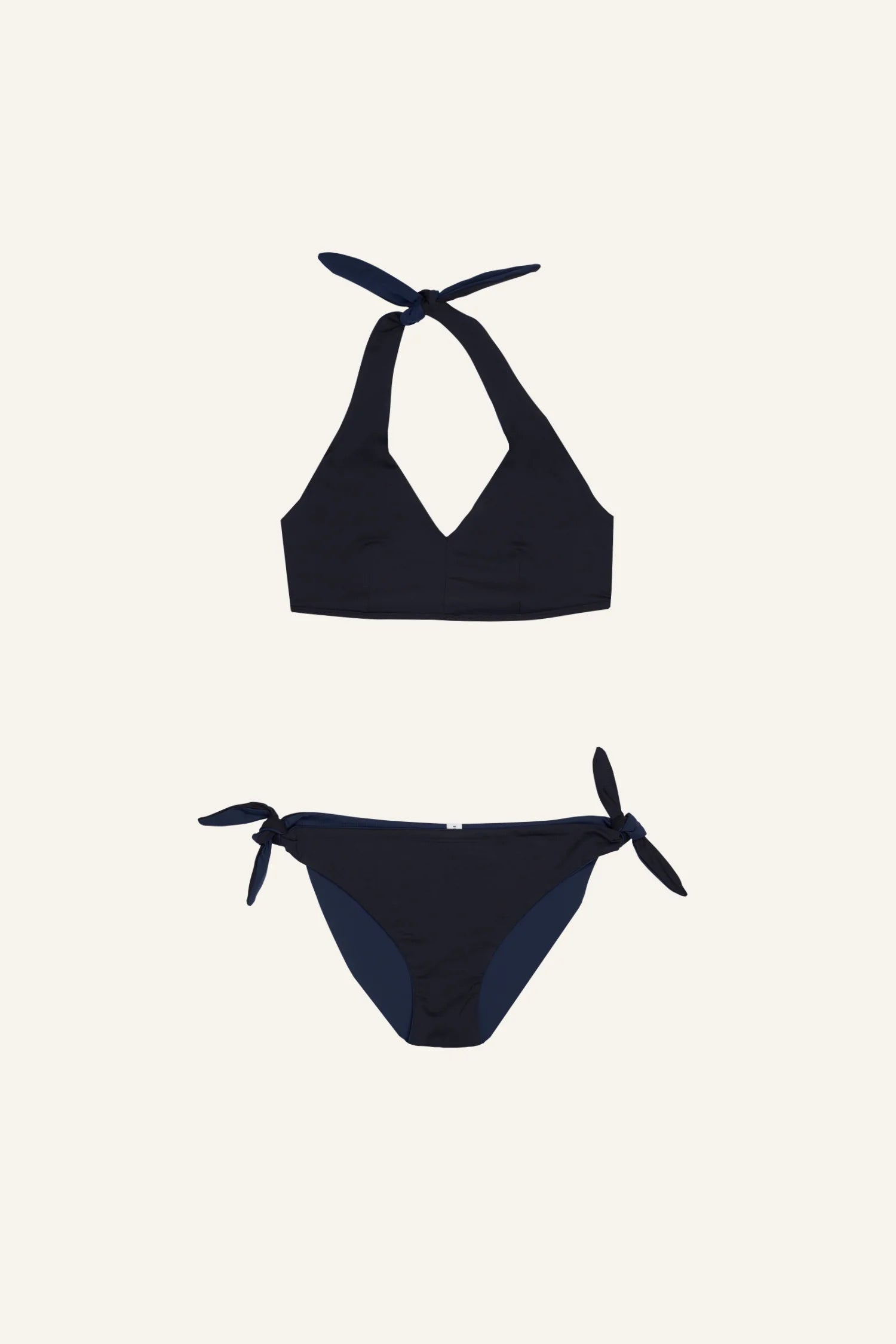 Schwarzer MYMARINI Bikini mit Neckholder-Top und seitlich gebundener Bikinihose auf hellem Hintergrund.#color_black-navy