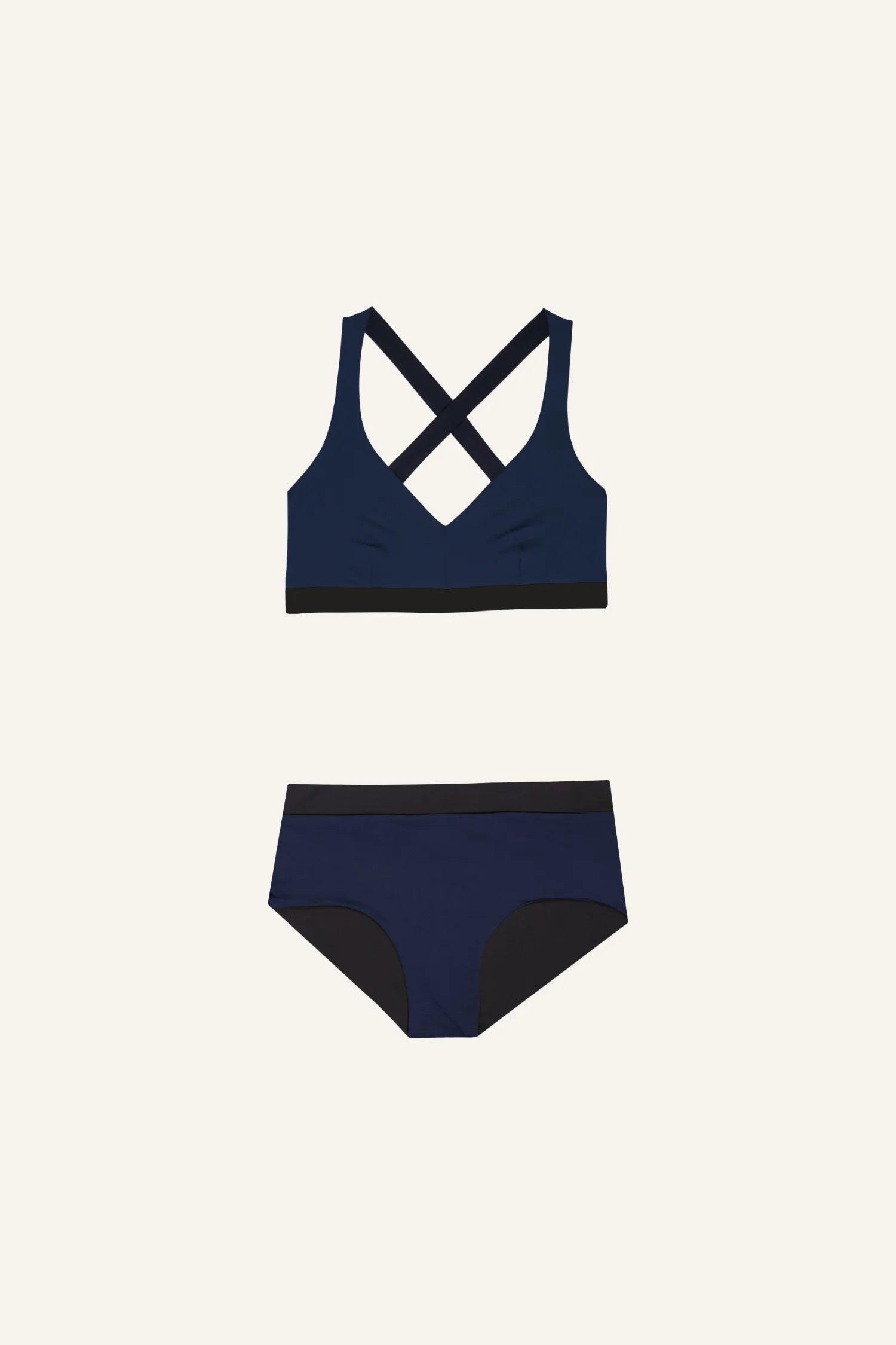 Dunkelblaues MYMARINI Bikinitop mit Cross-Back und Bikinihose mit Mid rise auf hellem Hintergrund.#color_black-navy